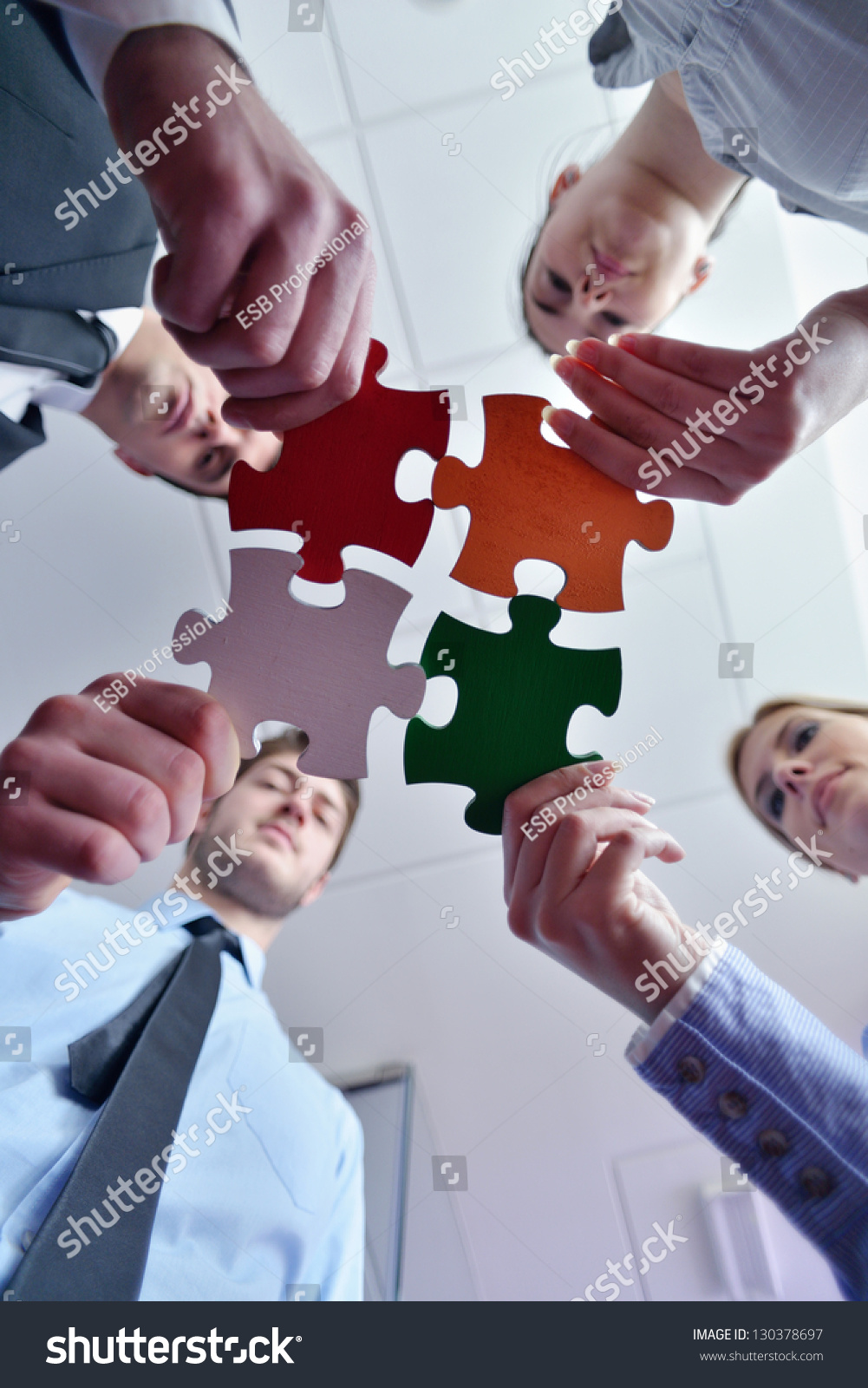 Group of business people assembling jigsaw puzzle and represent team support and help concept