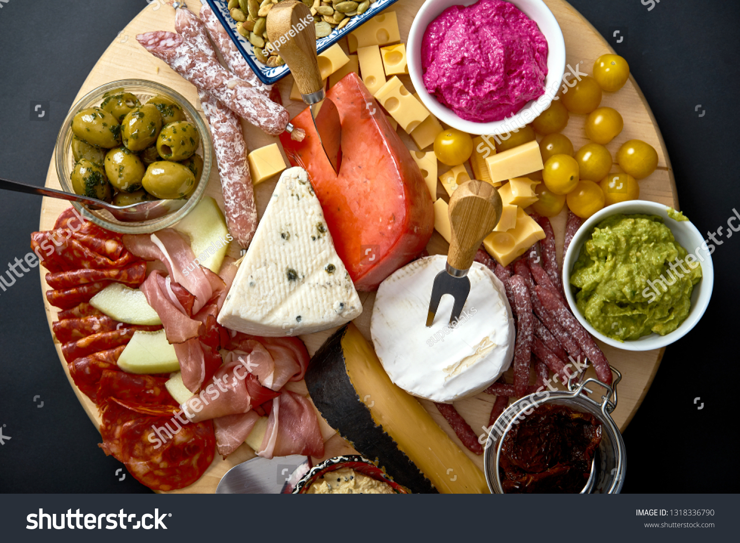 antipastiboardwithvariouscheeseandmeatsnackswithhummus