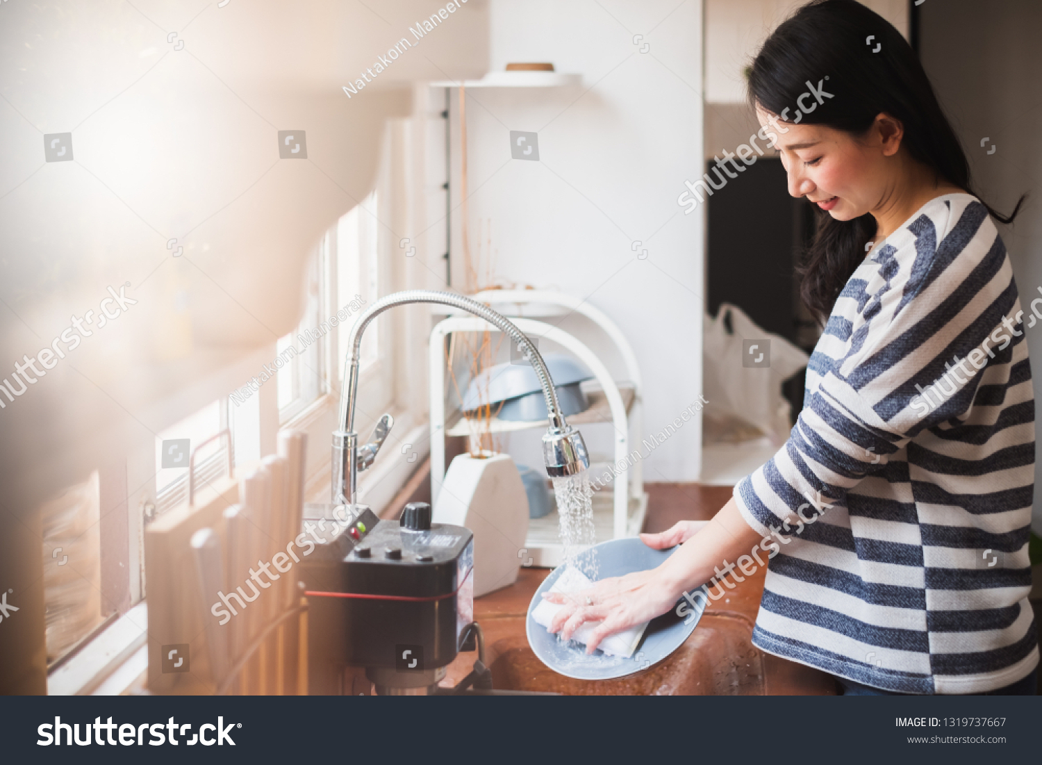 Asian maid housewife washing cleaning dishes in kitchen