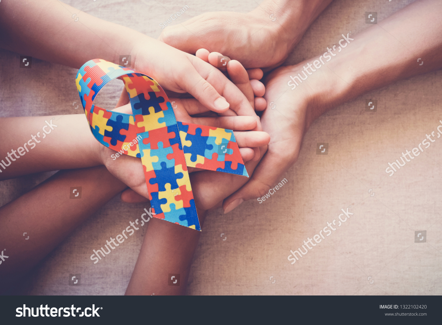 Hands holding puzzle ribbon  World Autism Awareness Day