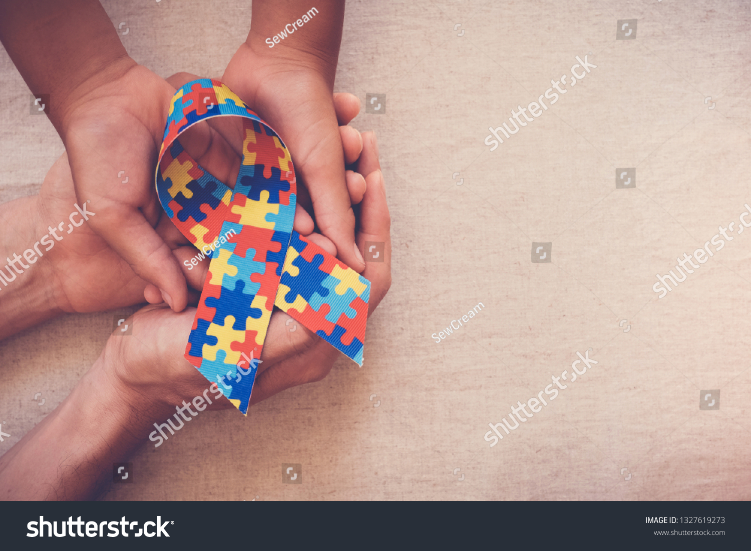 Hands holding puzzle ribbon for World Autism Awareness Day  pride  jigsaw