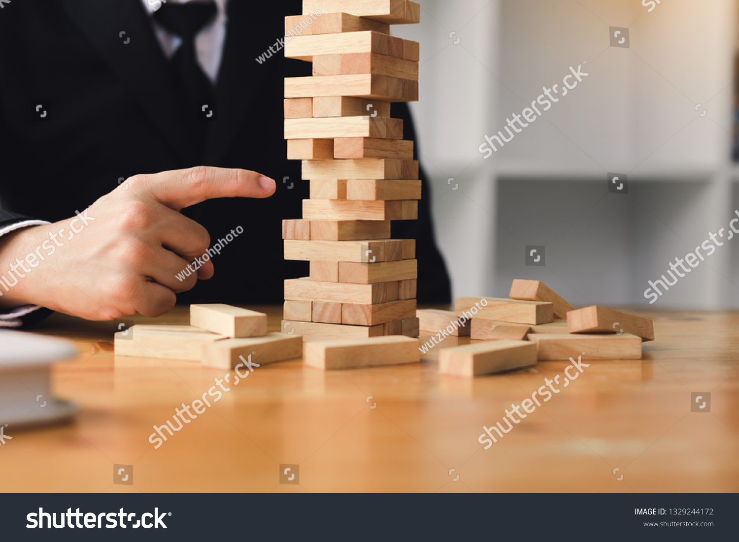 Strategic thinking and risk by business people pulls wooden blocks from the group.