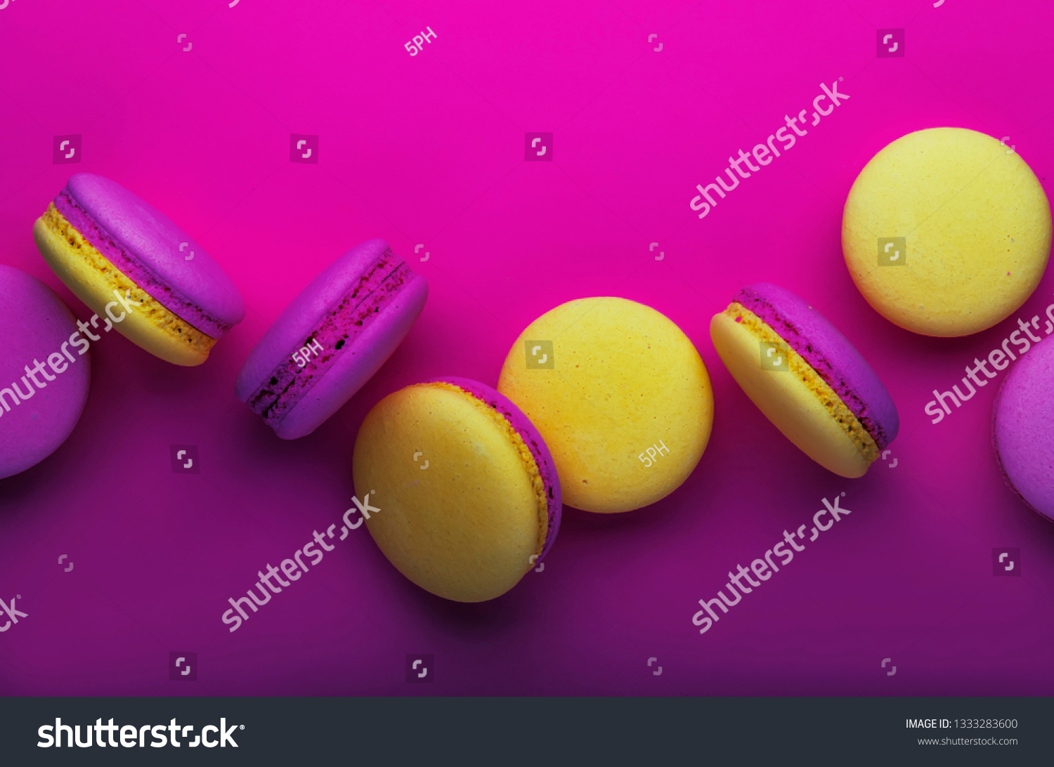 Pink yellow macaroons on soft pink background table  place for text  minimalism style  violet purple neon color  top view