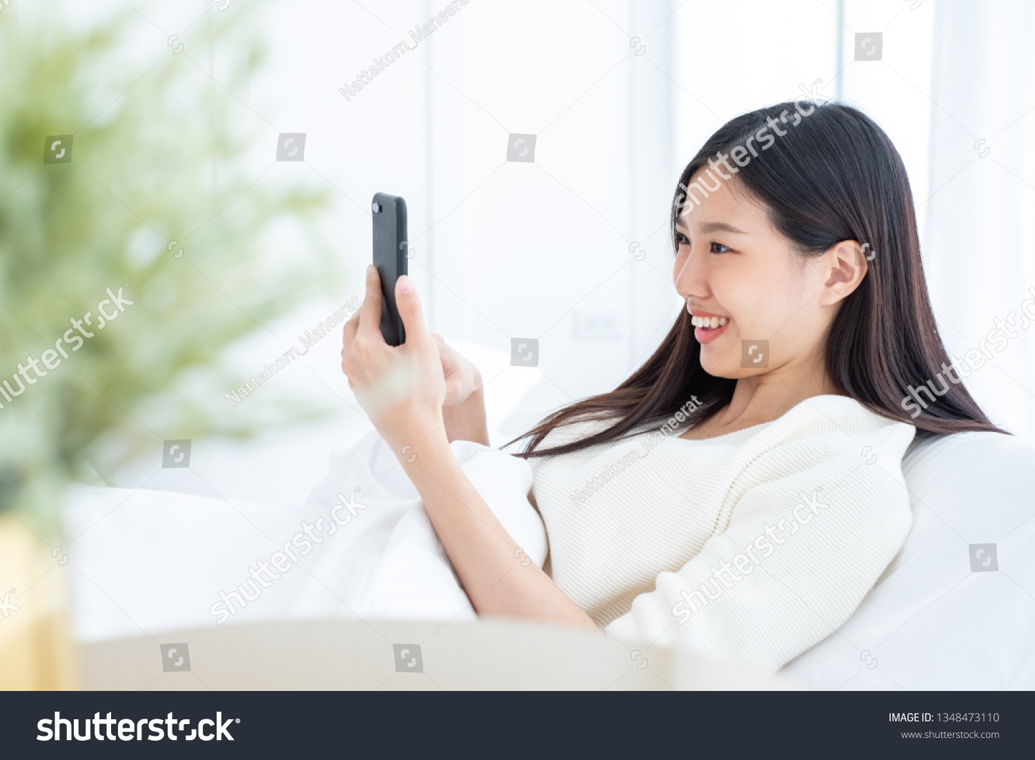 Beautiful Asian woman using smart phone in bed room for online shopping Asian woman lifestyle concept