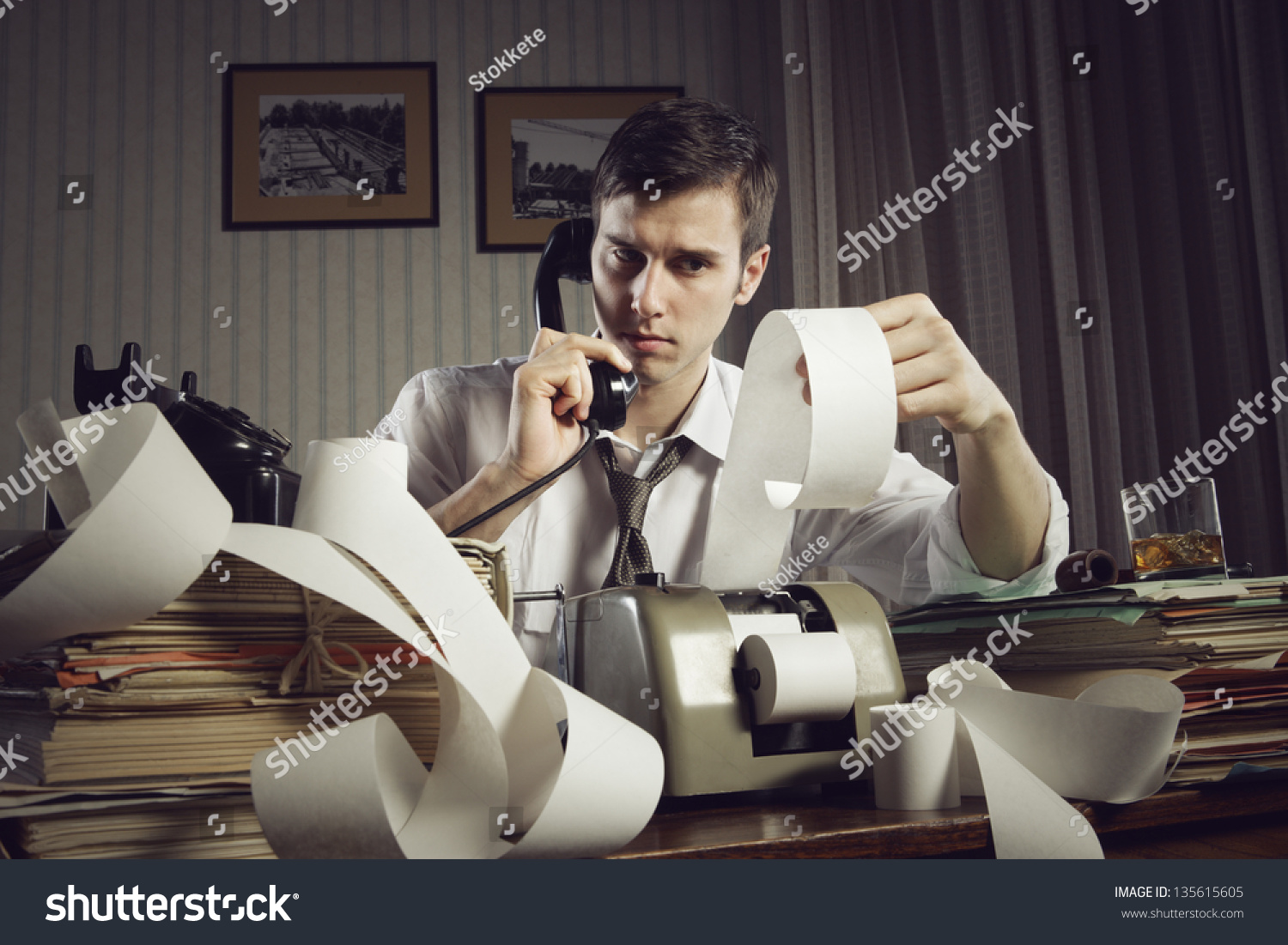 An male accountant at telephone  preparing income taxes