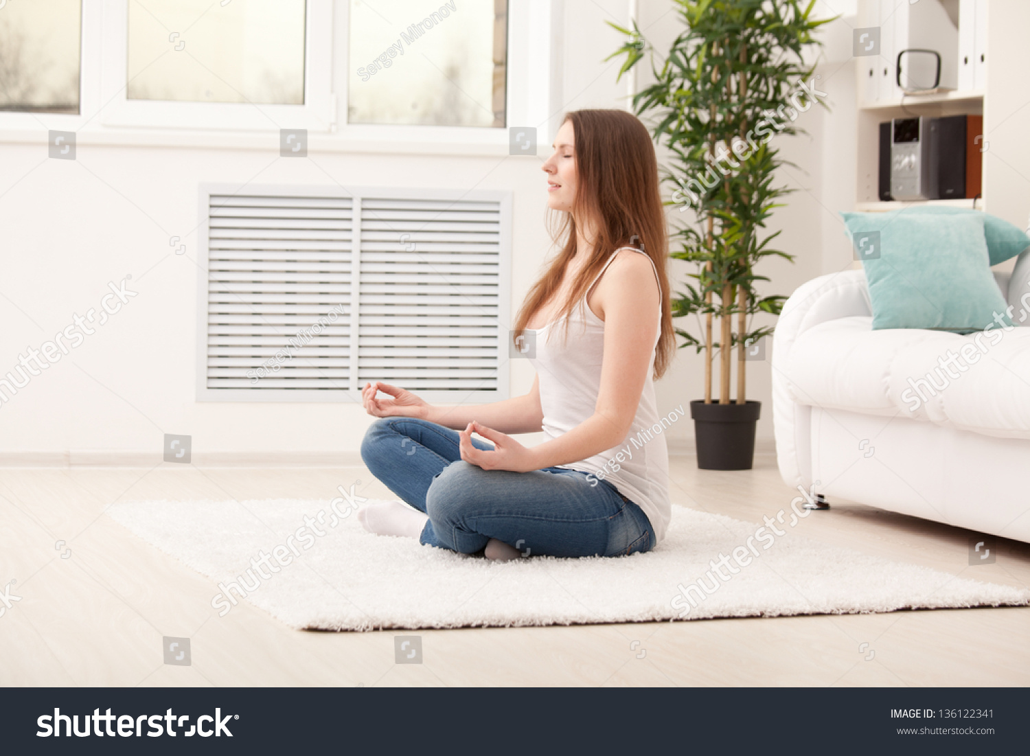 woman sitting on floor at home doing yoga meditation