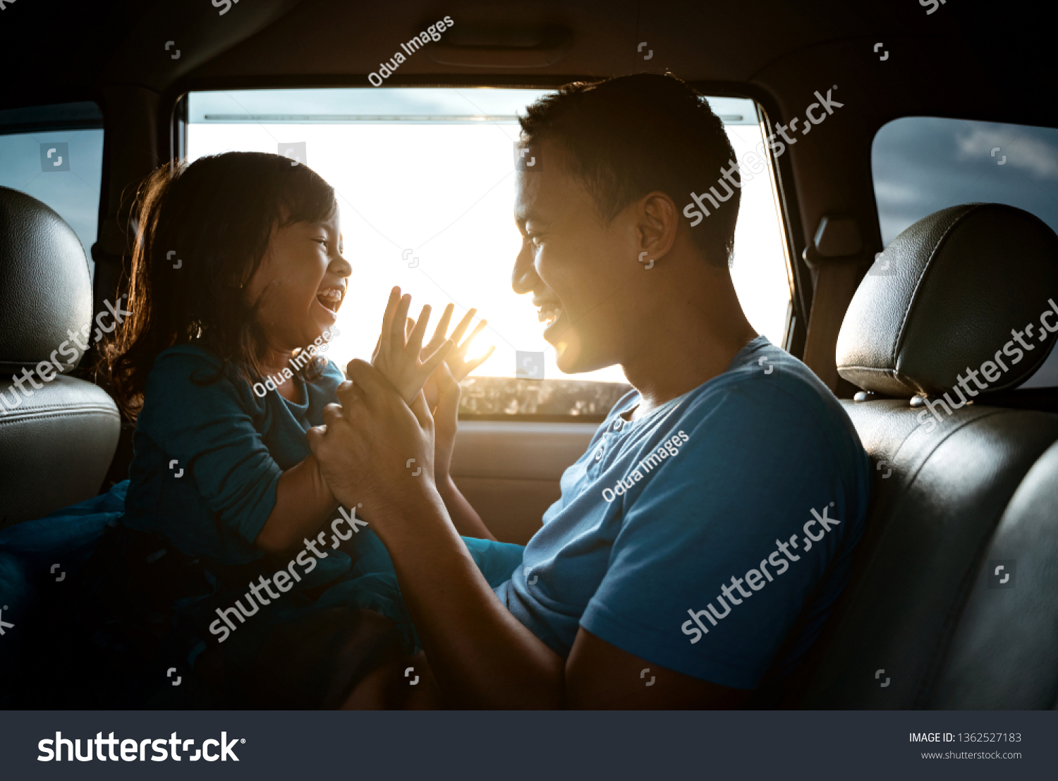 lovely asian daughter with father in the car playing together laughing