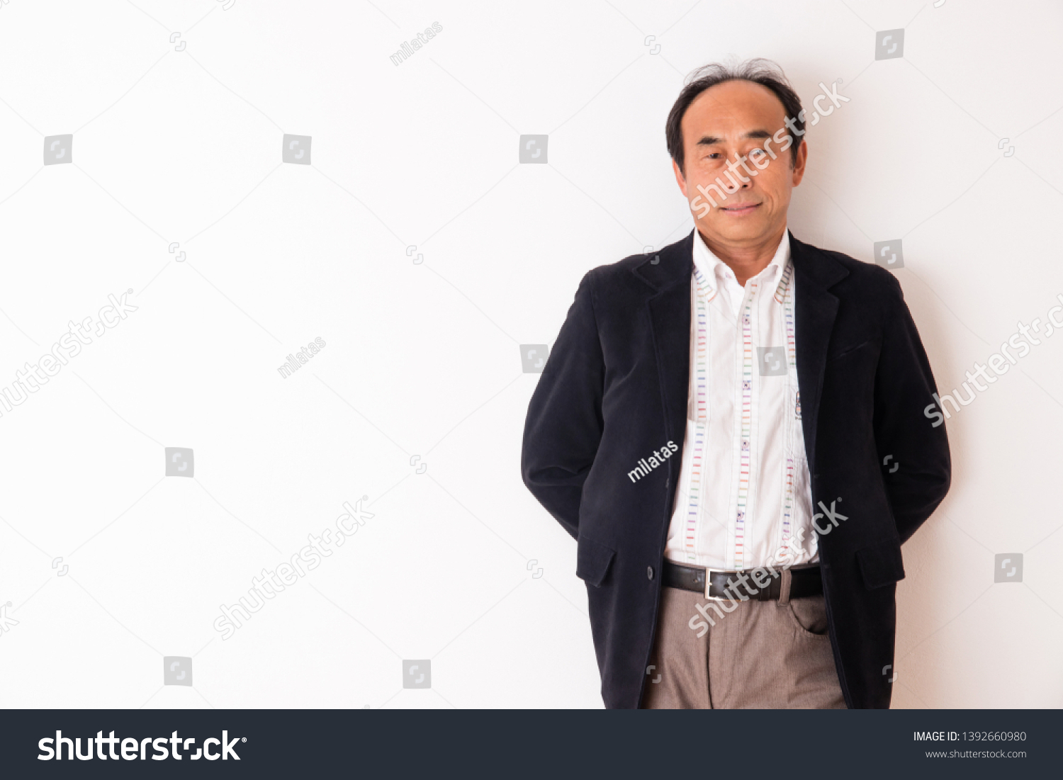 Portrait of senior man in front of white wall