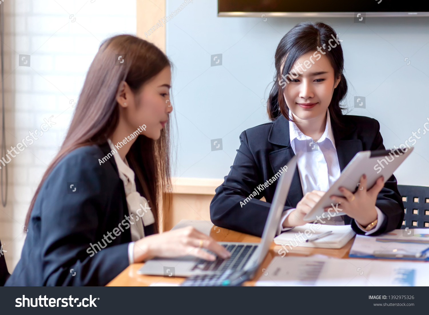 Two business woman Asian chat exchanging ideas at the meeting.