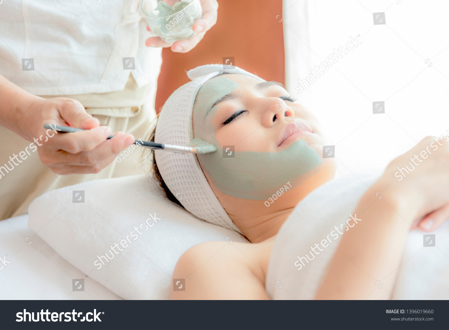 Close-up side view relaxing Beautiful young asian woman enjoy relaxing getting during Face peeling mask skin care spa beauty treatment by beautician at spa salon center.