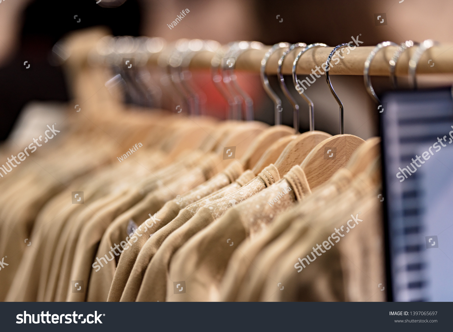 wooden hangers in a row with light clothing in the store