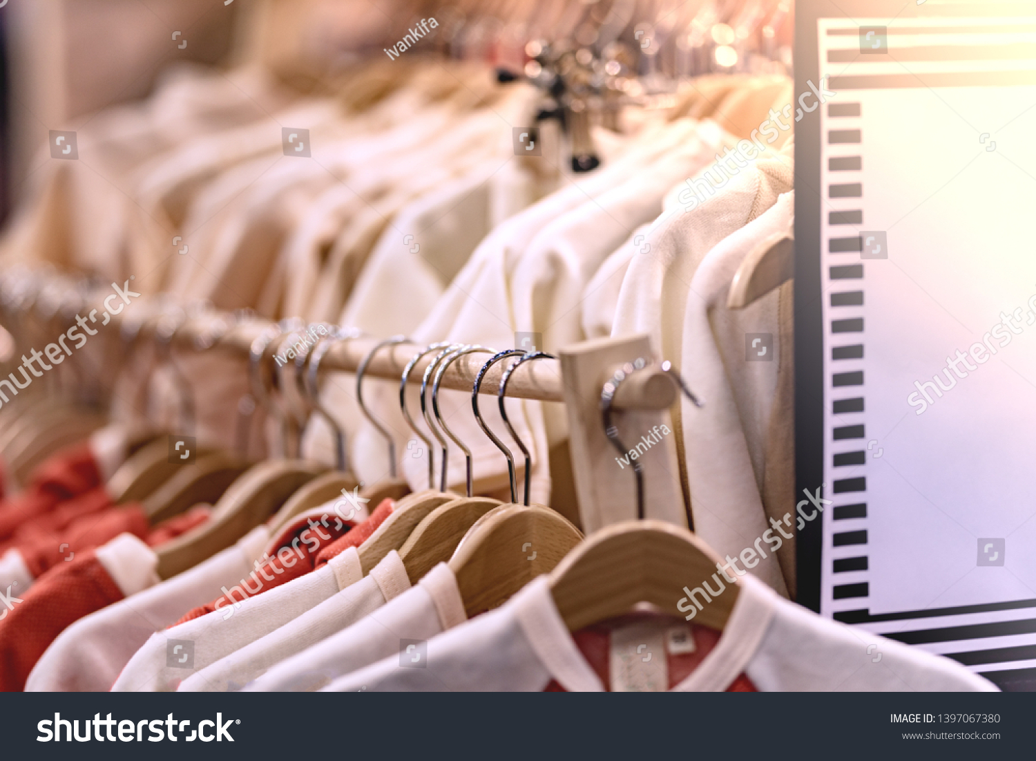 wooden hangers in a row with light clothing in the store