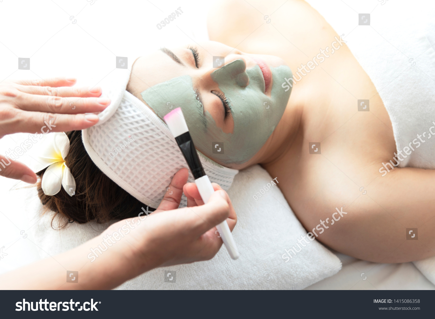 Close-up side view relaxing Beautiful young asian woman enjoy relaxing getting during Face peeling mask skin care spa beauty treatment by beautician at spa salon center.