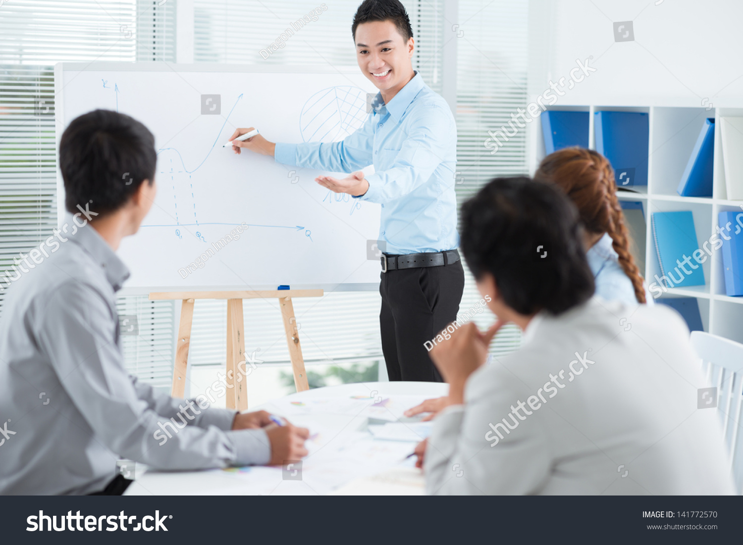 Image of a businessman presenting a new strategy to his colleagues