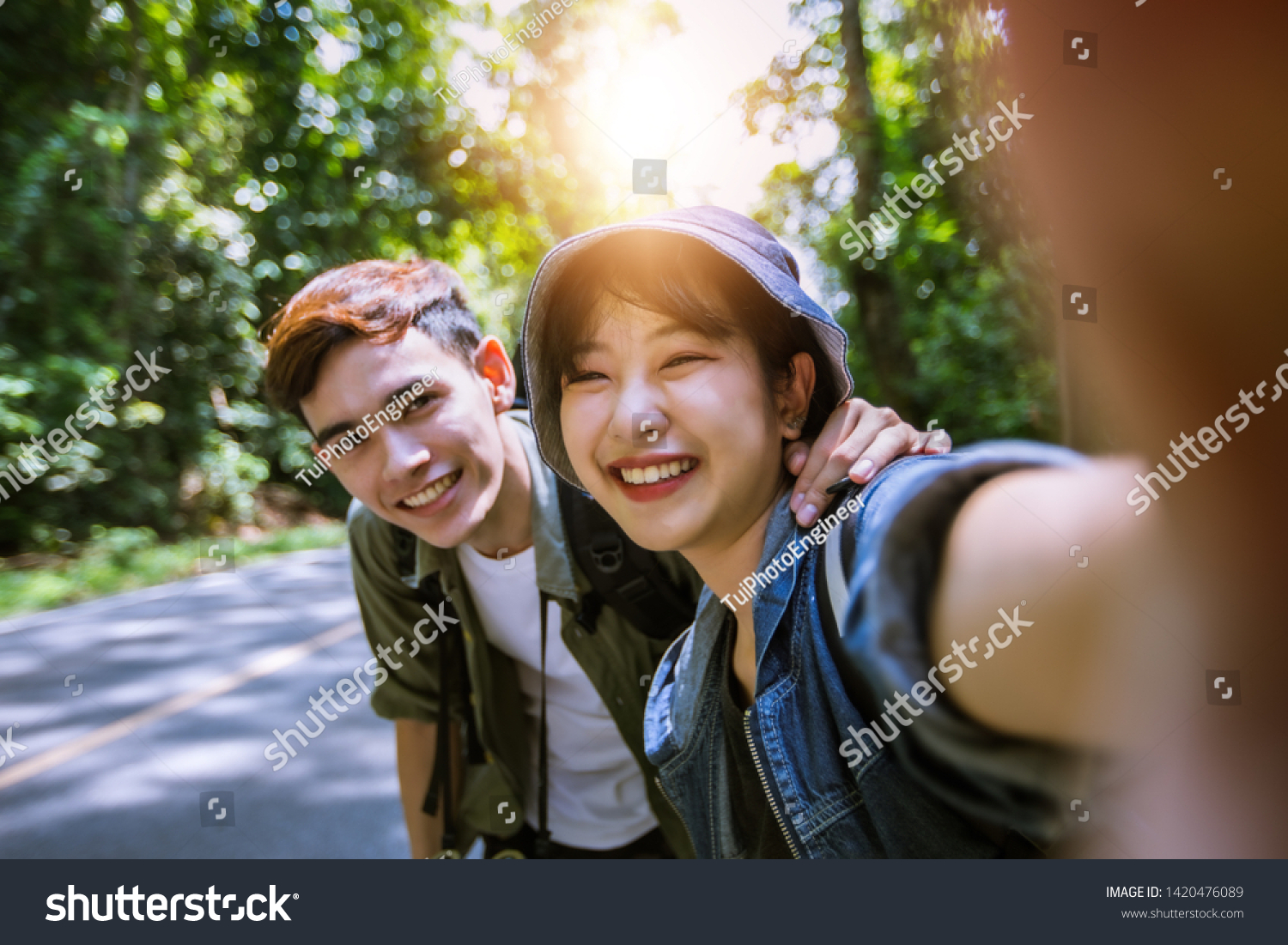Asian Group of young people with friends and backpacks walking together and happy friends are taking photo and selfie Relax time on holiday concept travel