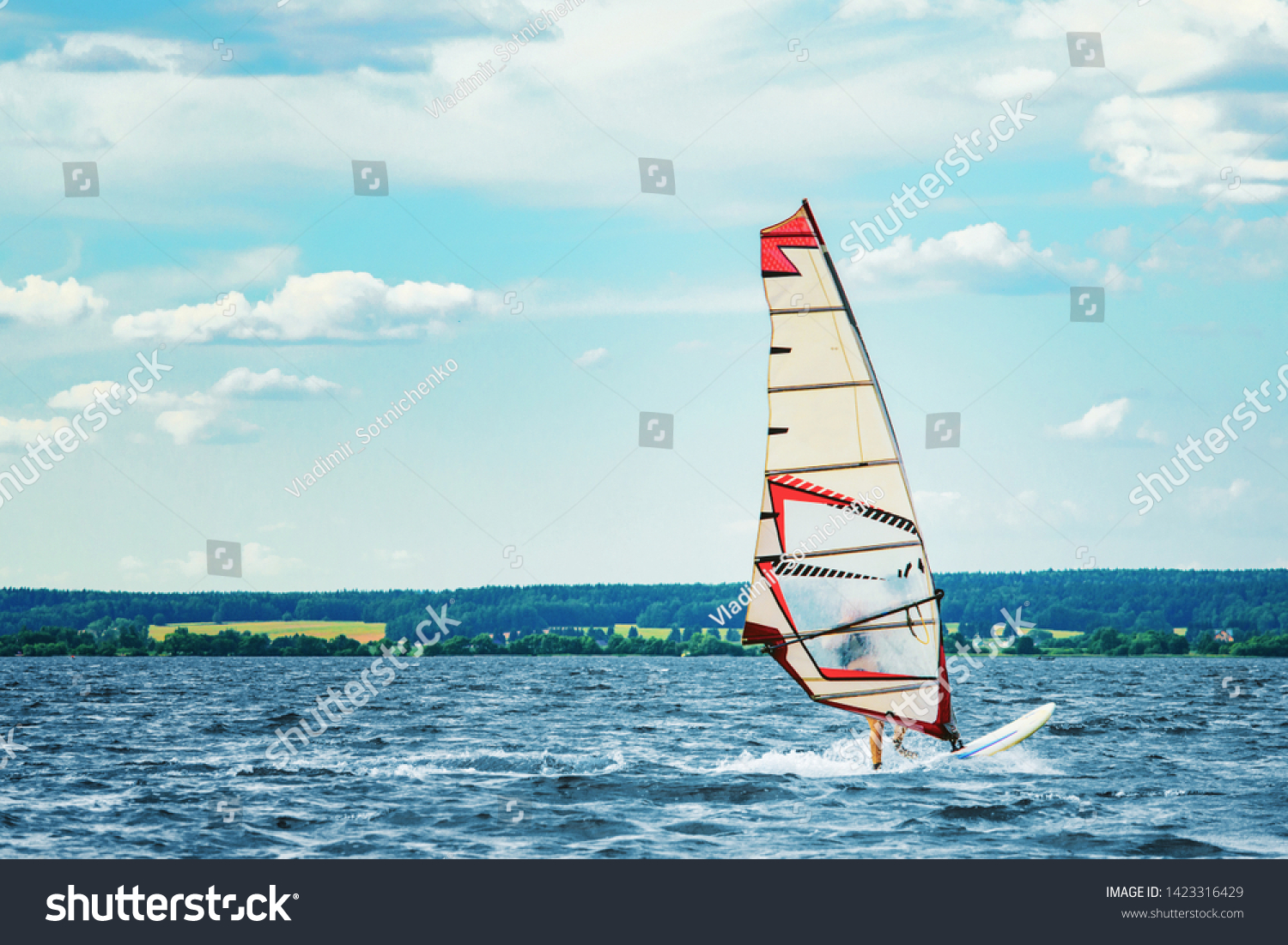 Windsurfer catches the wind and cuts the waves while driving fast