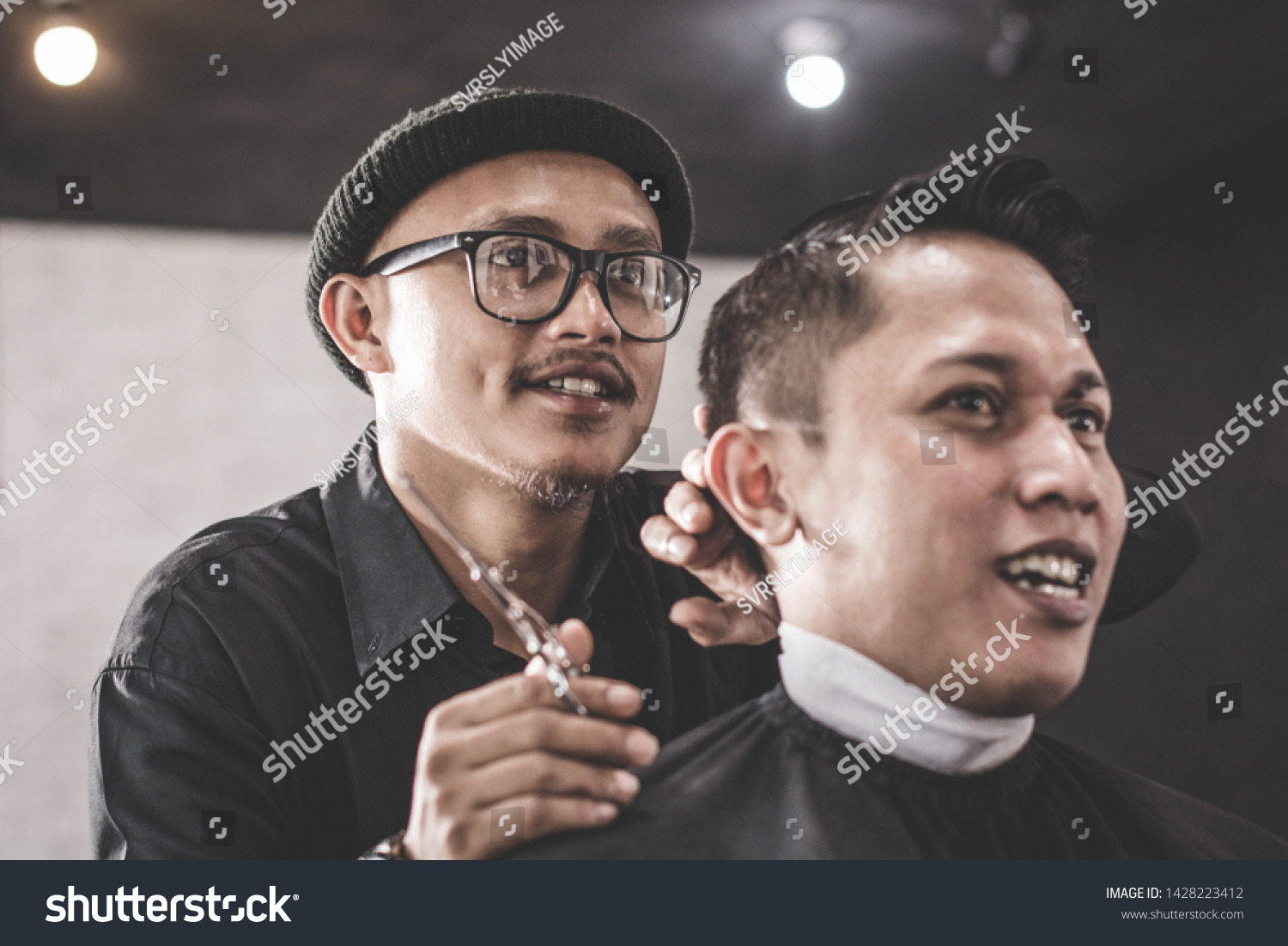 close up portrait of barber hairstyle styling hair of his costumer hair who sitting in chair with hand pomade and comb in barbershop or salon