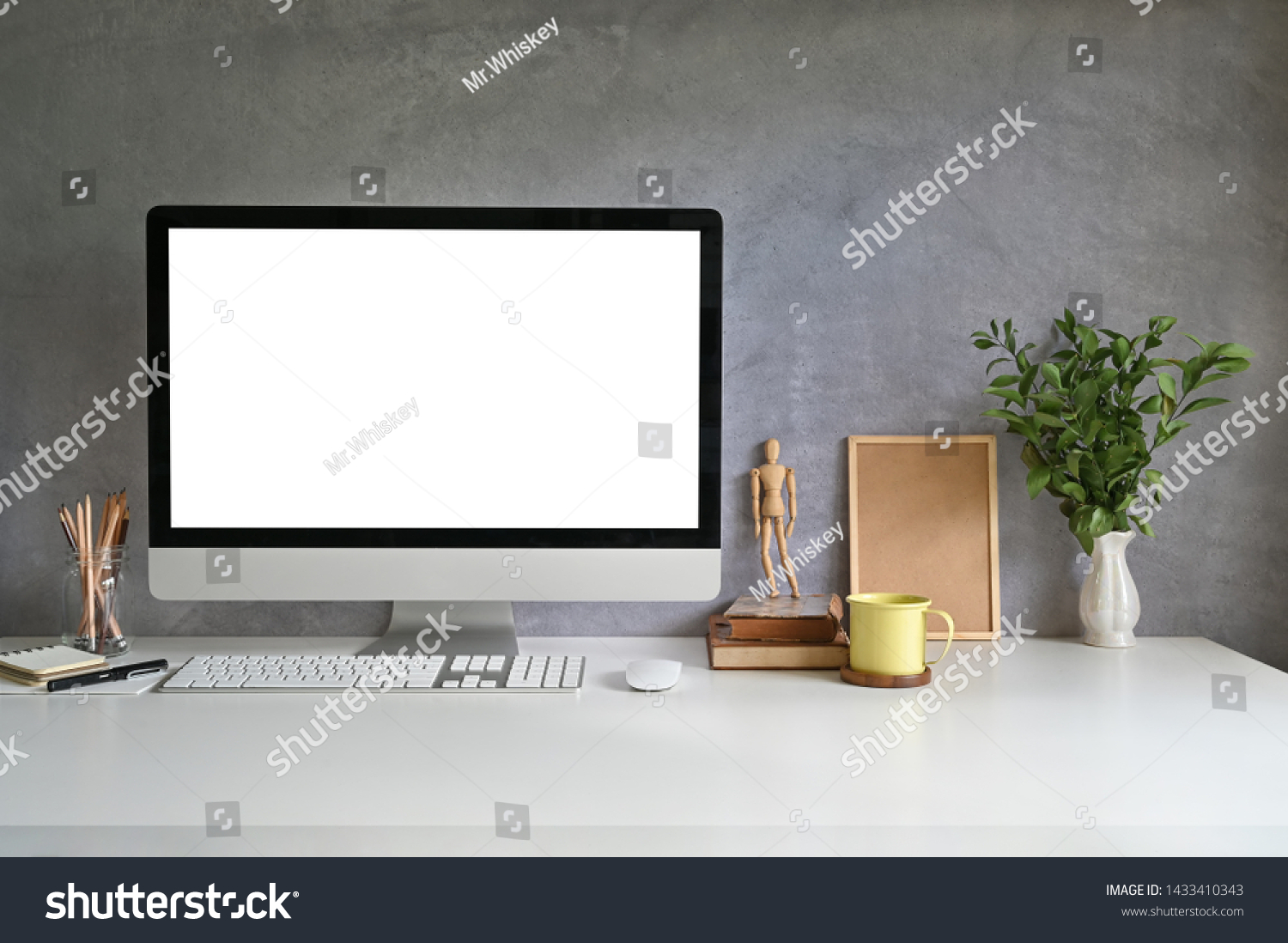 PC computer on workspace with coffee mug  pencil  books and plant on office desk.