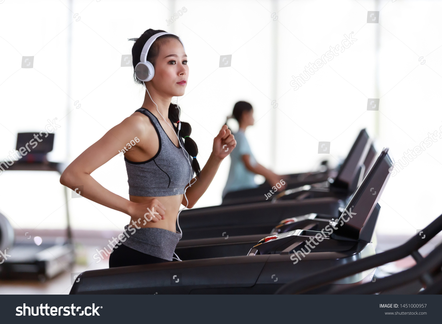 Fitness woman wearing headphone cardio workout at fitness gym.