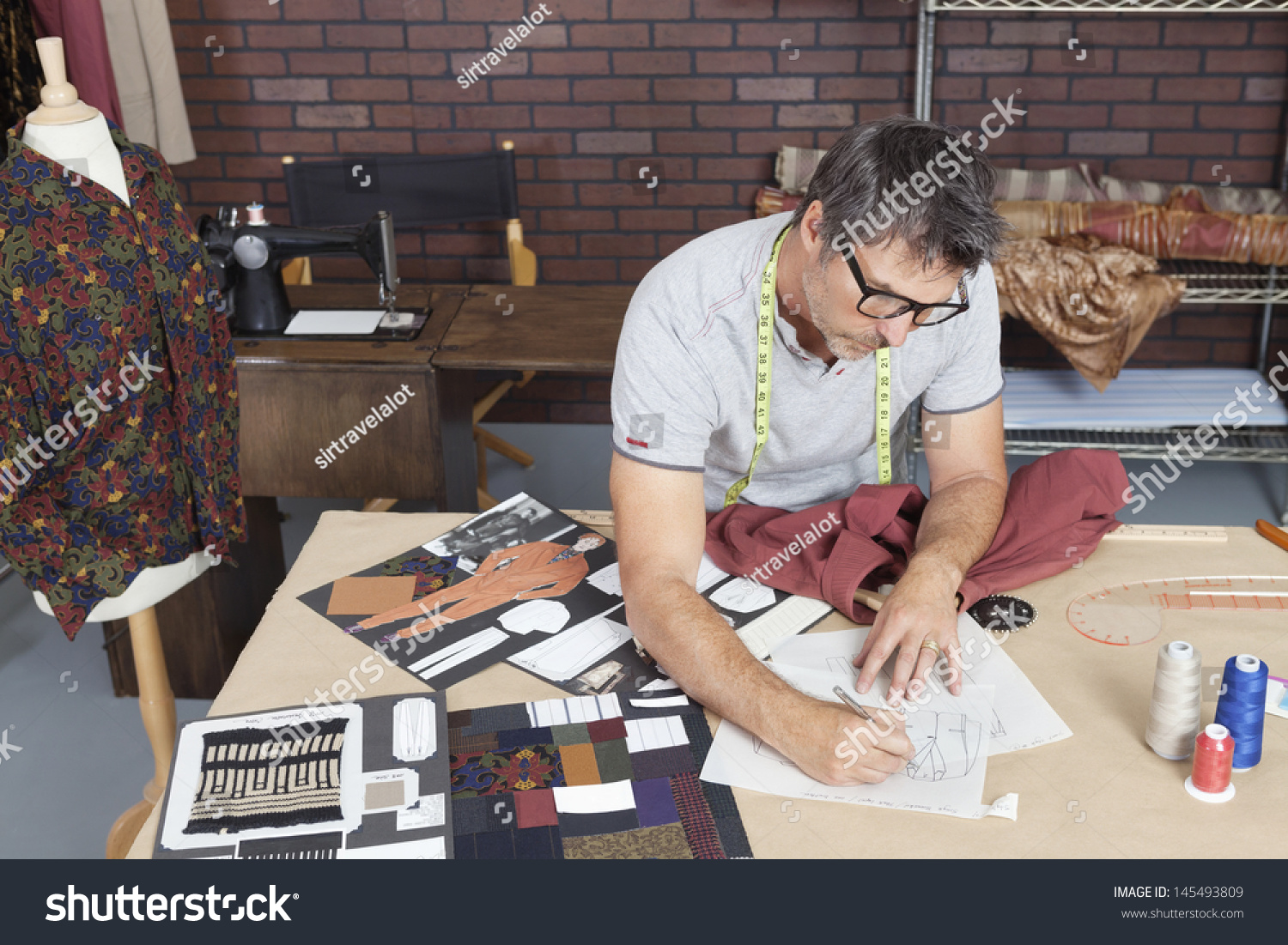 Mature male fashion designer working on sketch in design studio