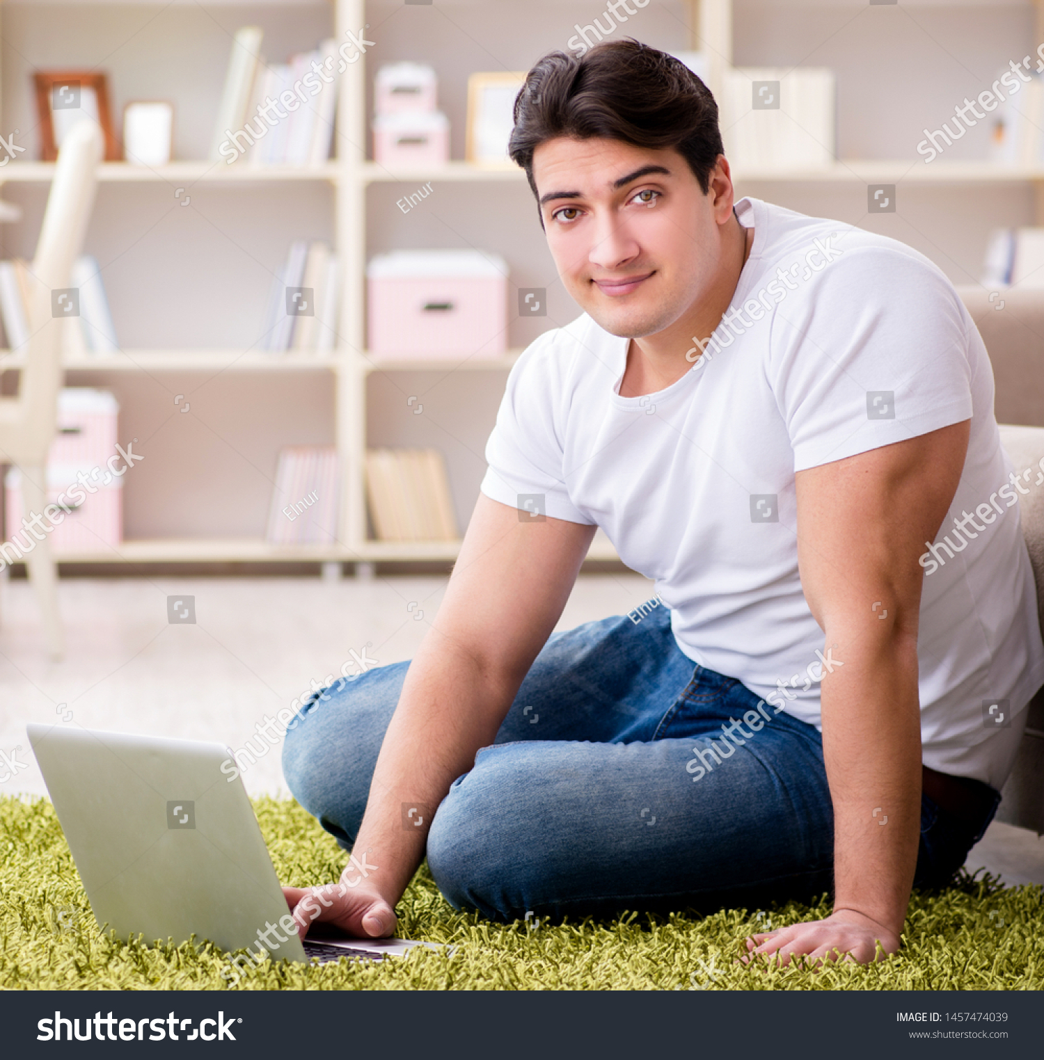 manworkingonlaptopathomeoncarpetfloor