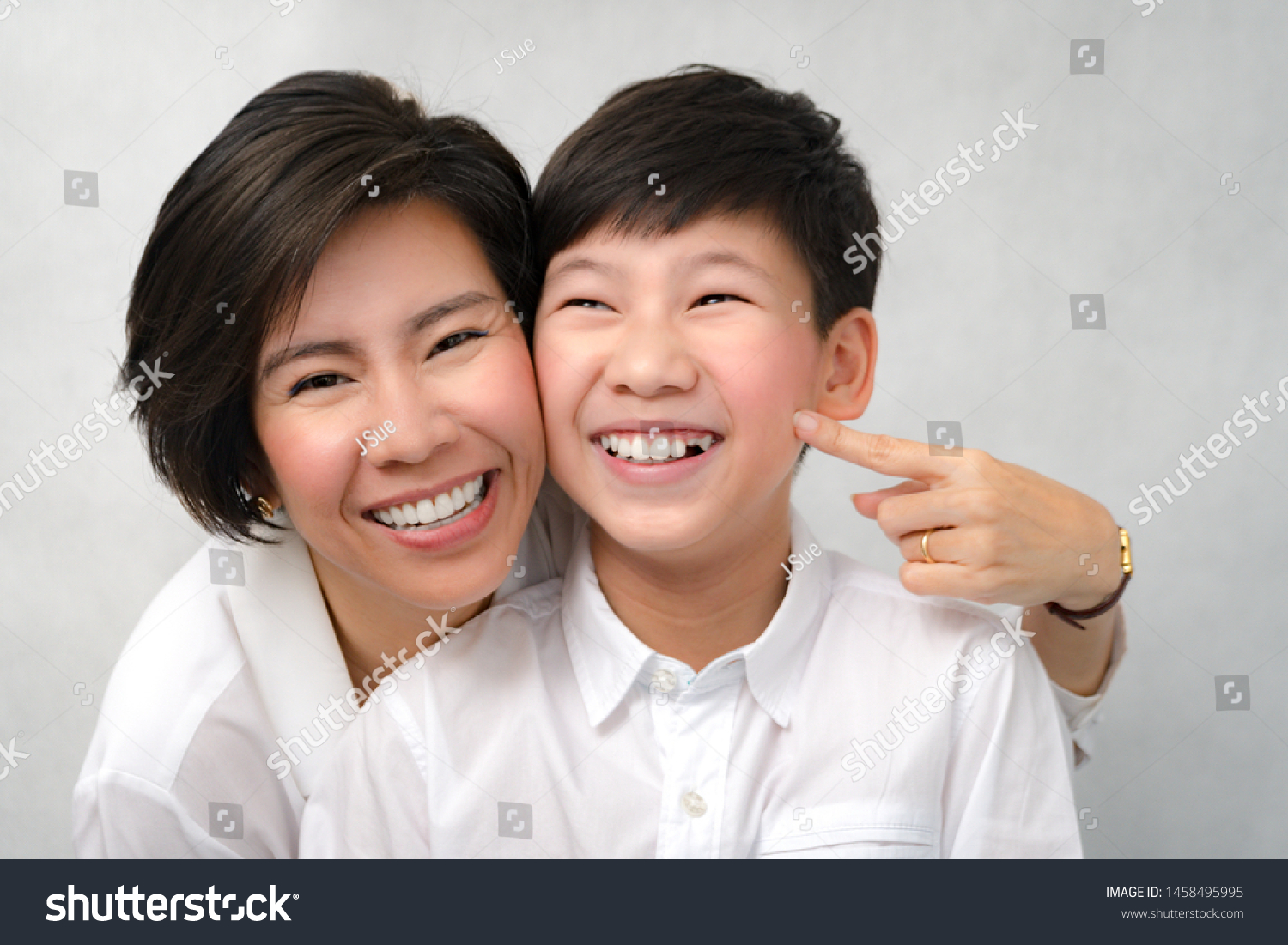 A happy face of asian smart looking preteen boy and mom laughing together. Deciduous teeth  Milk teeth  Healthy and strong  Dental oral care  Bonding  Mother and son  Studio portrait white background.