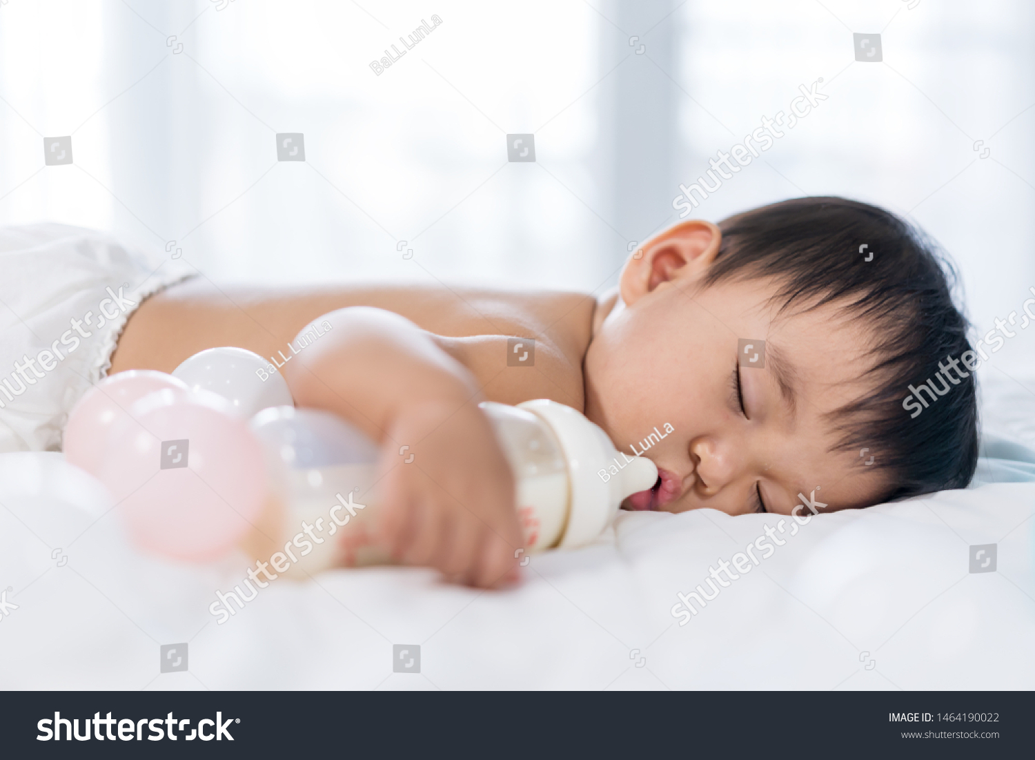Baby sleeping on a bed after drinking bottle milk