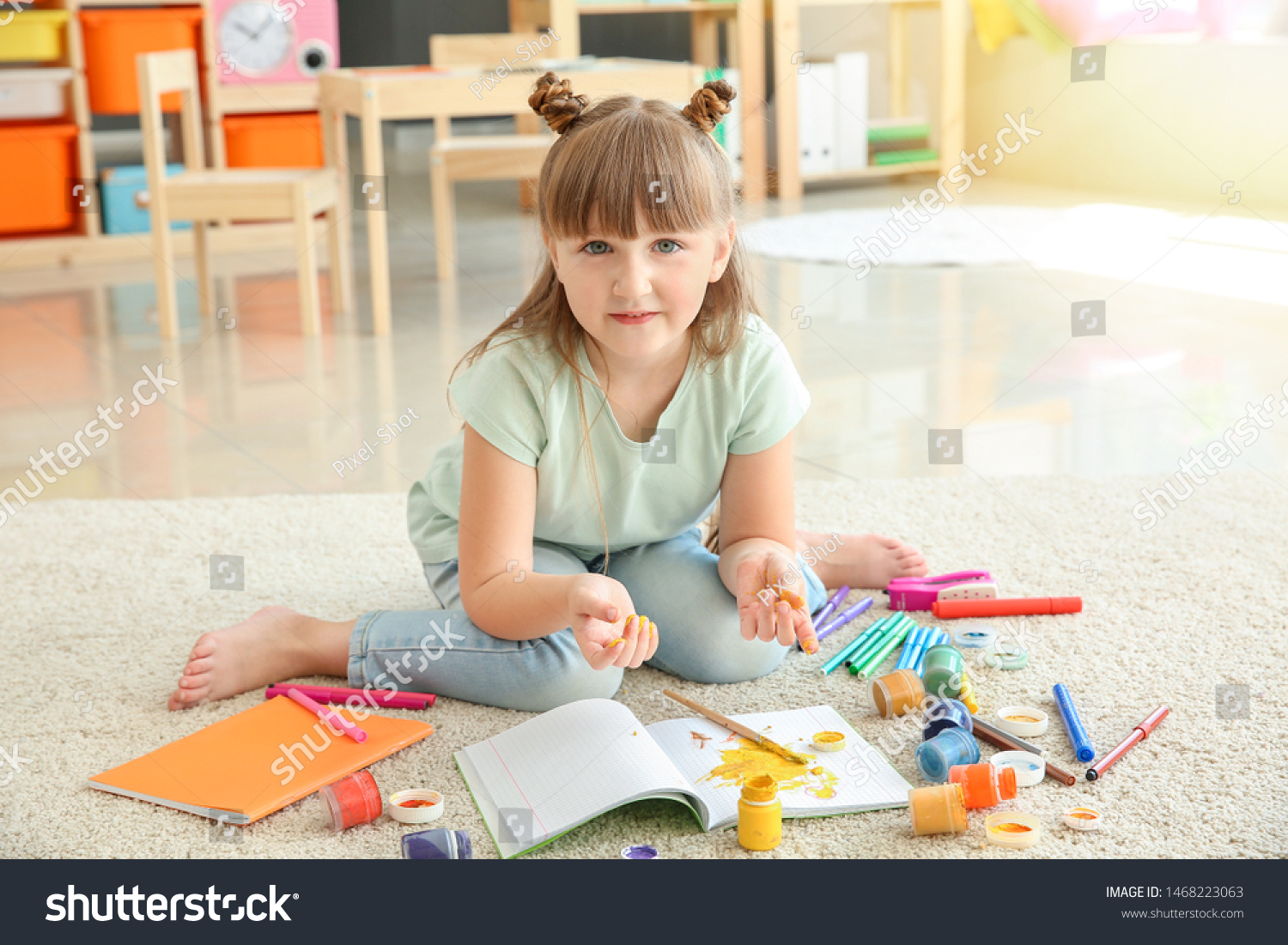 cutelittlegirlpaintingwhilesittingoncarpet