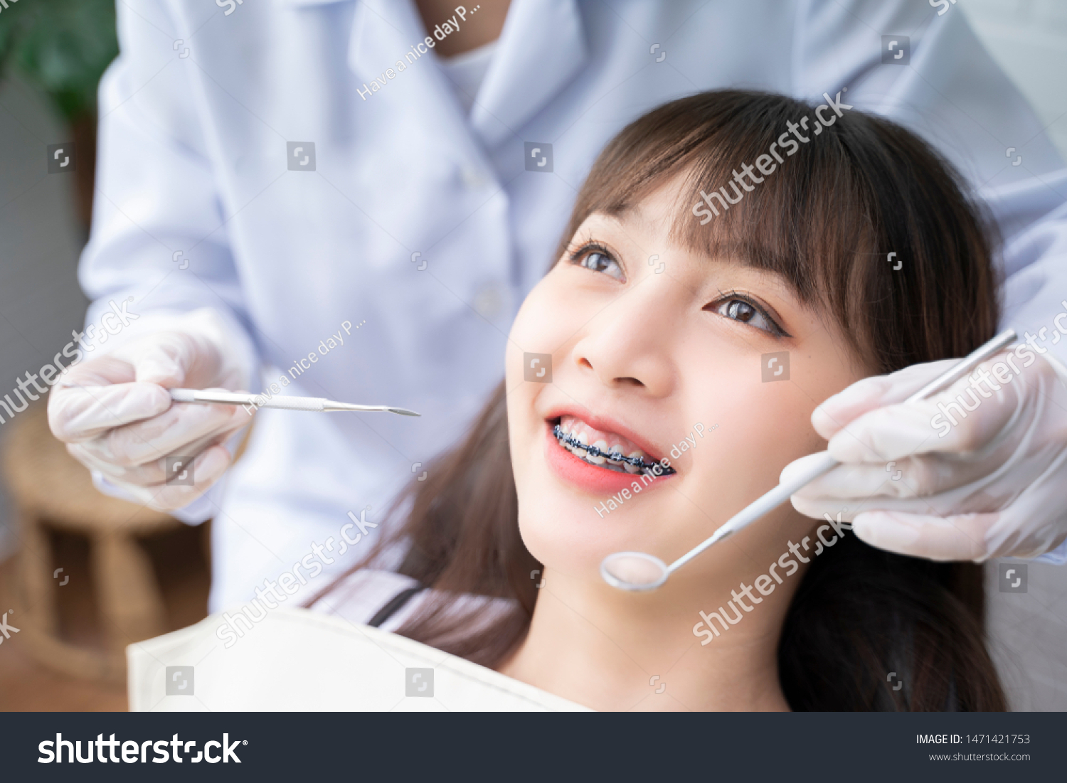 Asian Doctor Dentist examine female patient with braces in a dental office wearing gloves standing in clinic check Close Up young braces Asian woman Beautiful Asian girl smiles in dentistry.