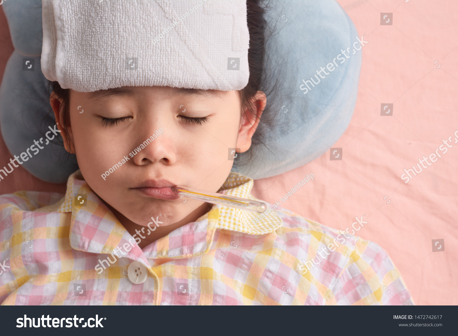 Sleep Sick Asian Girl On a Pink Bed There is a thermometer in the mouth. Is an infection from the school. with Space for your Text.
