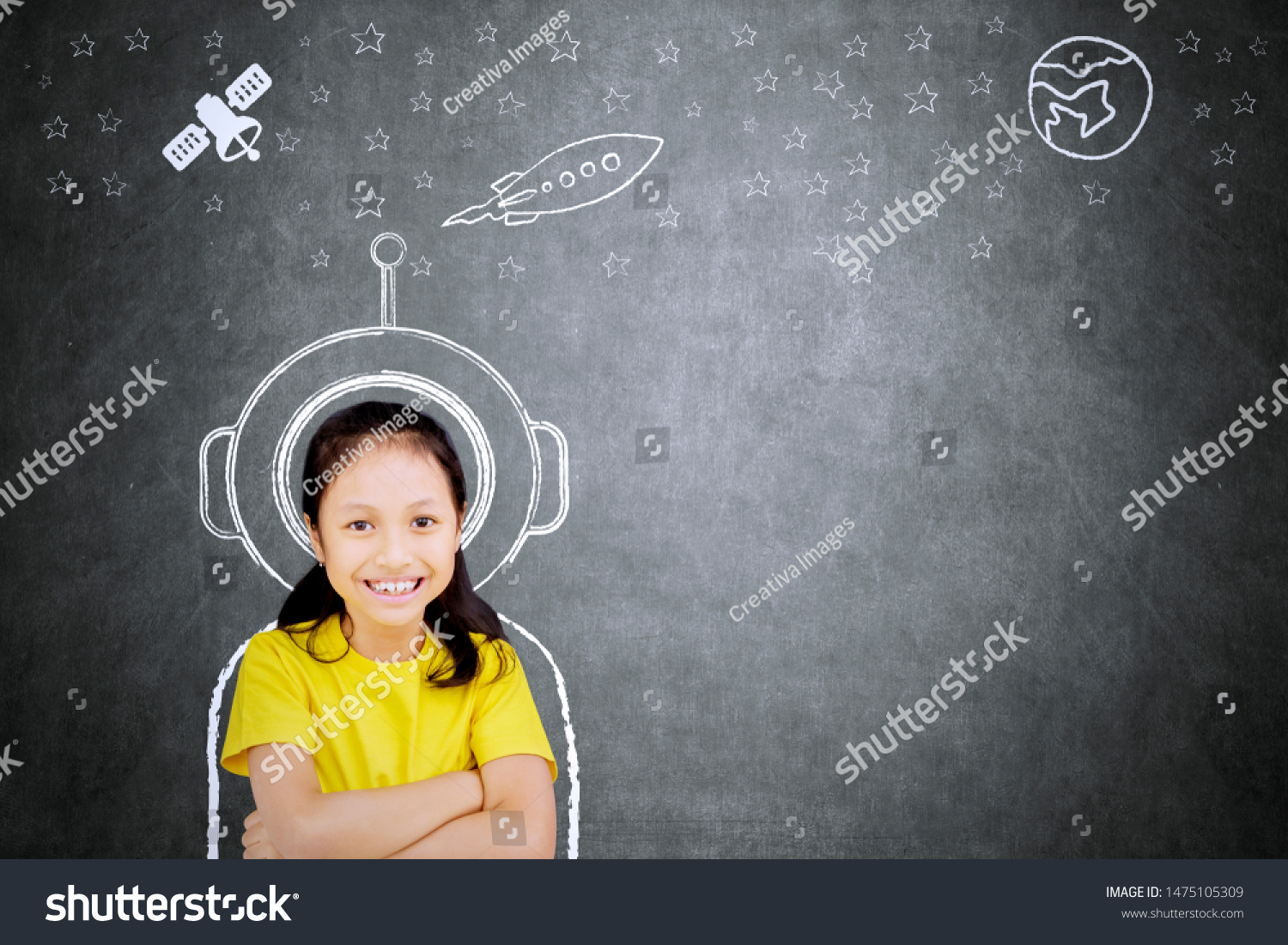 Picture of confident schoolgirl smiling at the camera while imagining being an astronaut