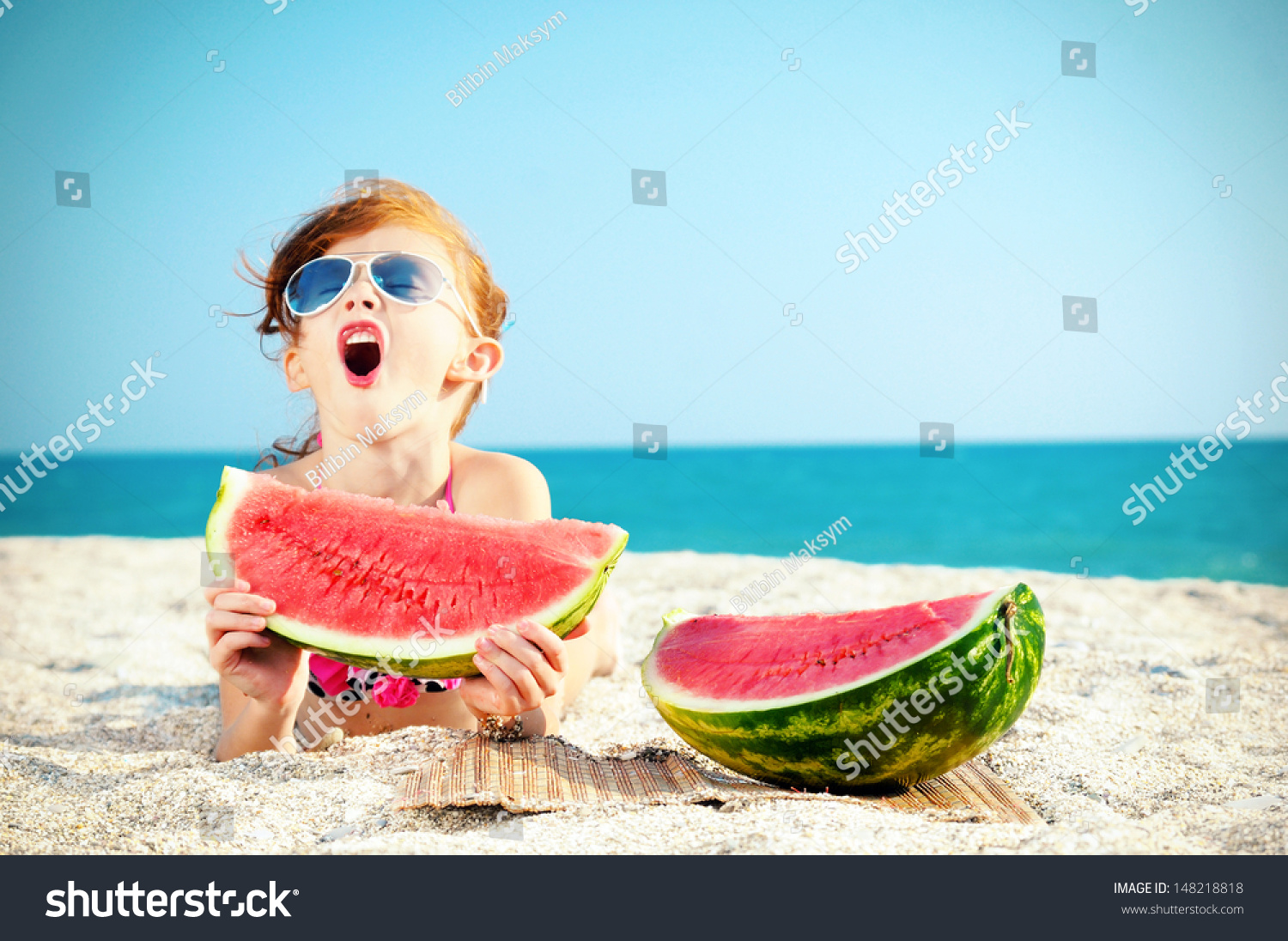 Happy child on the sea with watermelon