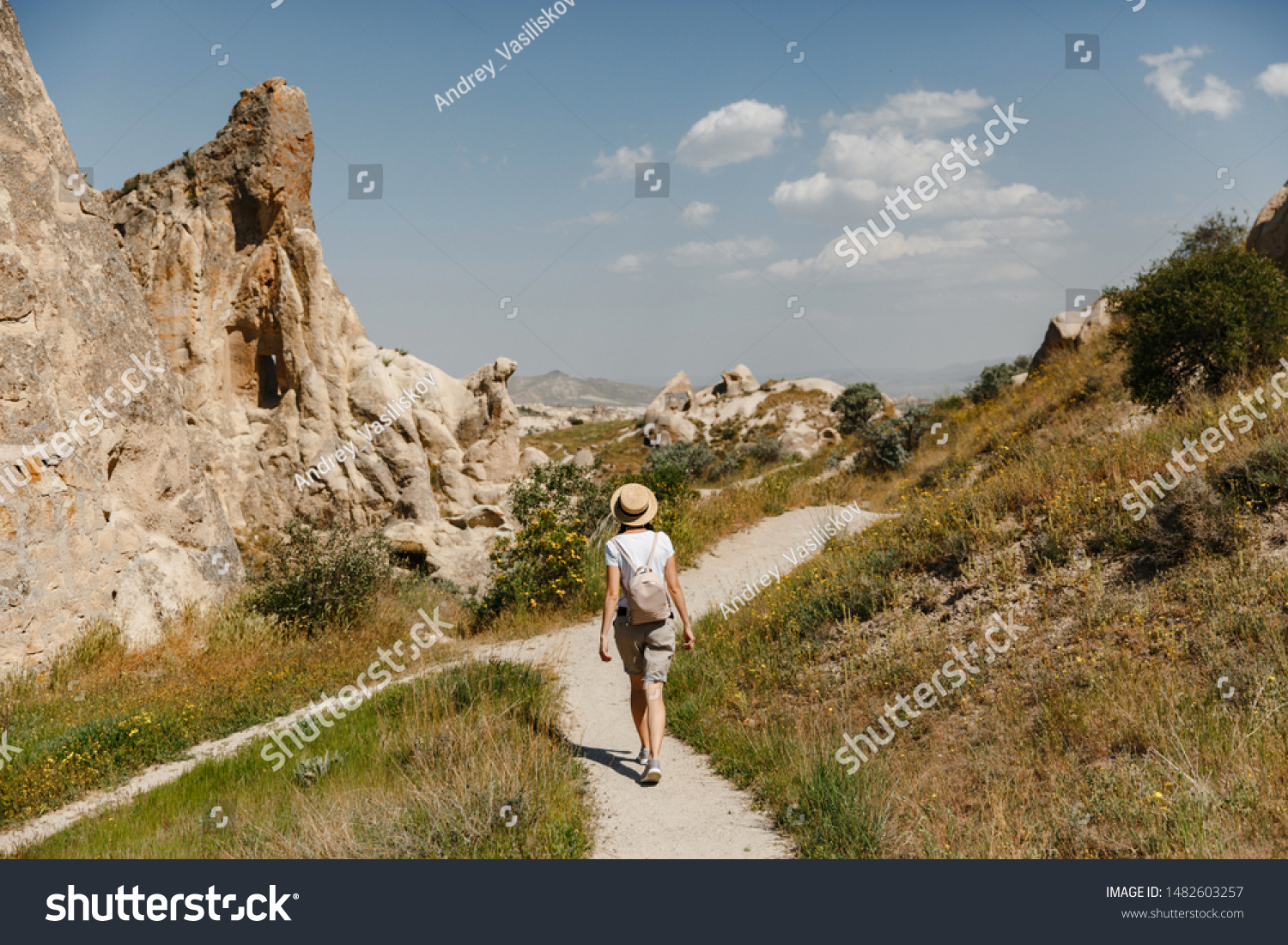 Girl tourist at the top of the mountain enjoying the beautiful view of the valley in Cappadocia. Happy travelling in Turkey concept