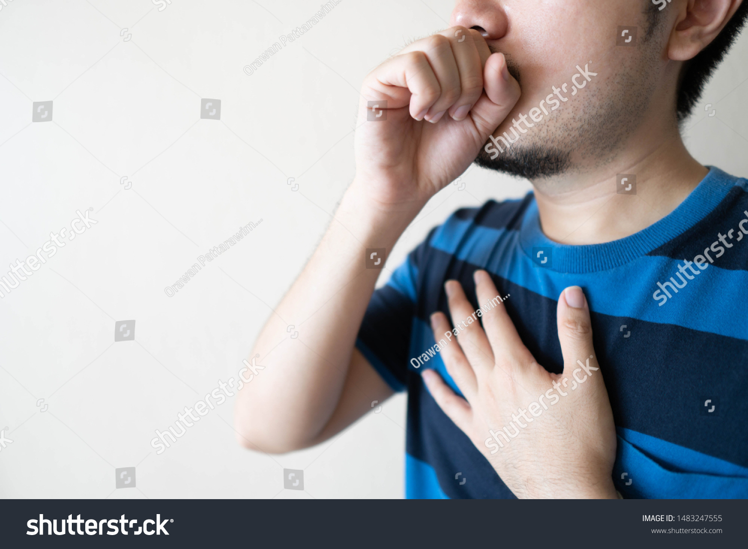Young ill man have a cough and sore throat over white background. Causes of cough include pneumonia bronchitis allergy asthma COPD TB or respiratory tract infection. Copy space. Health care.