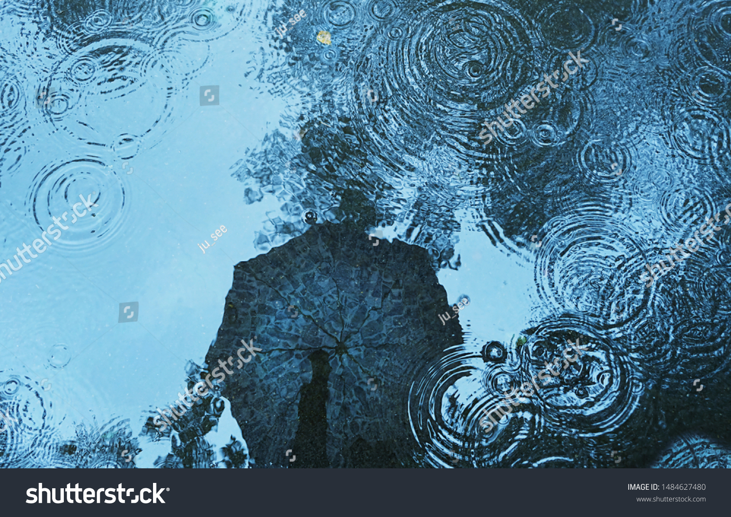 reflection umbrella in puddle background. abstract rain backdrop. soft selective focus