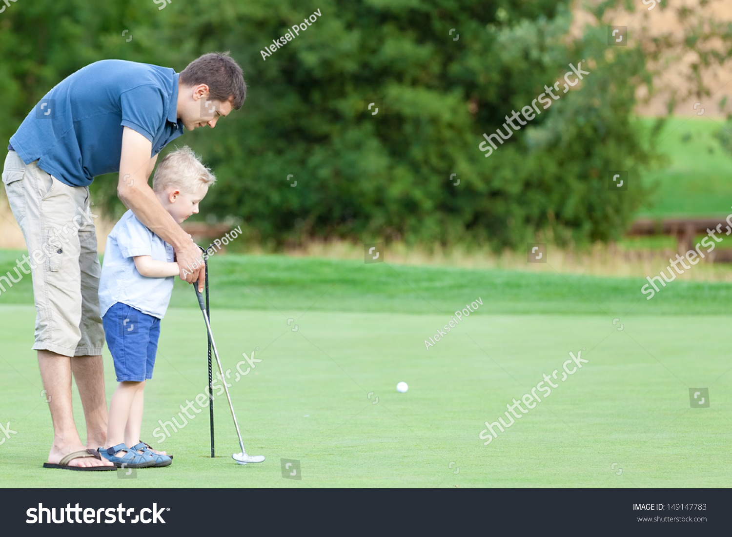 handsome father and his cute son playing golf together