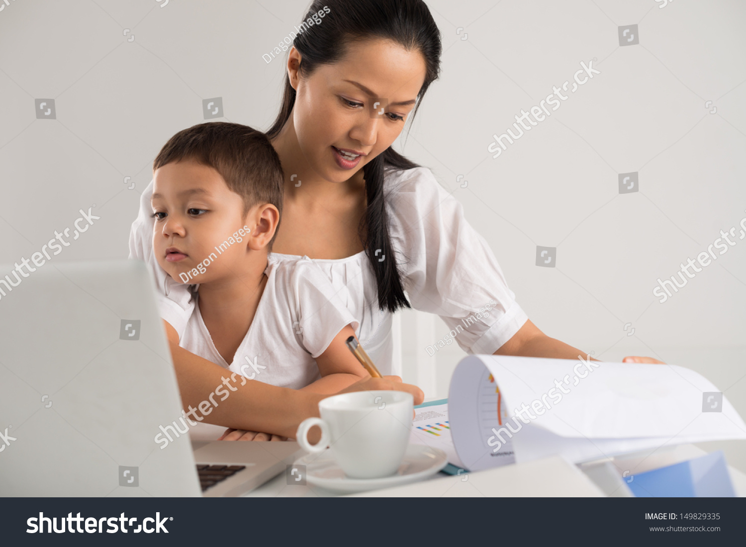 Mother sitting with her child and working at the same time