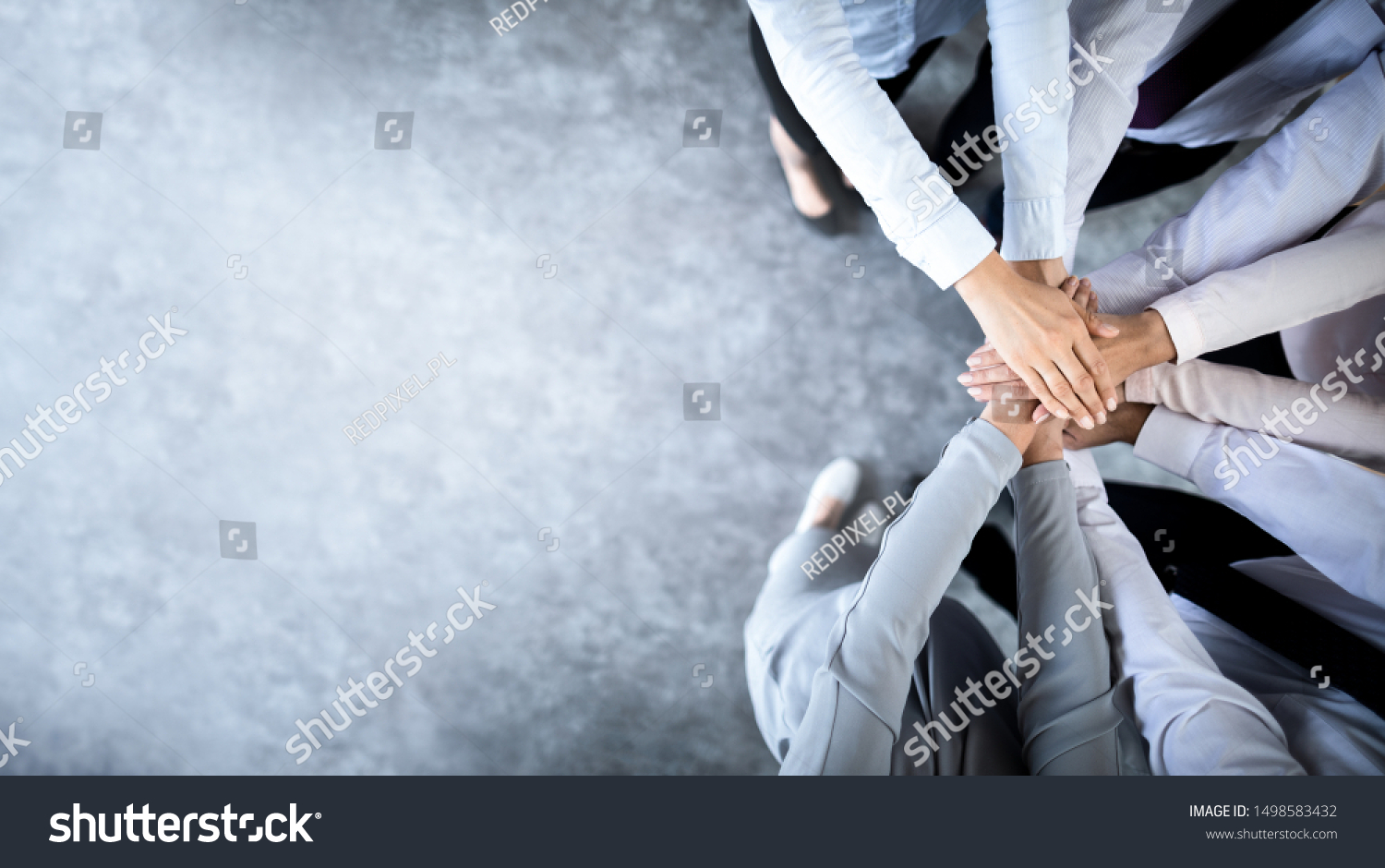 Close up top view of young business people putting their hands together. Stack of hands. Unity and teamwork concept.