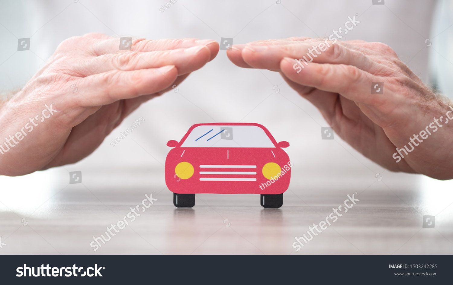 Car protected by hands - Concept of auto insurance