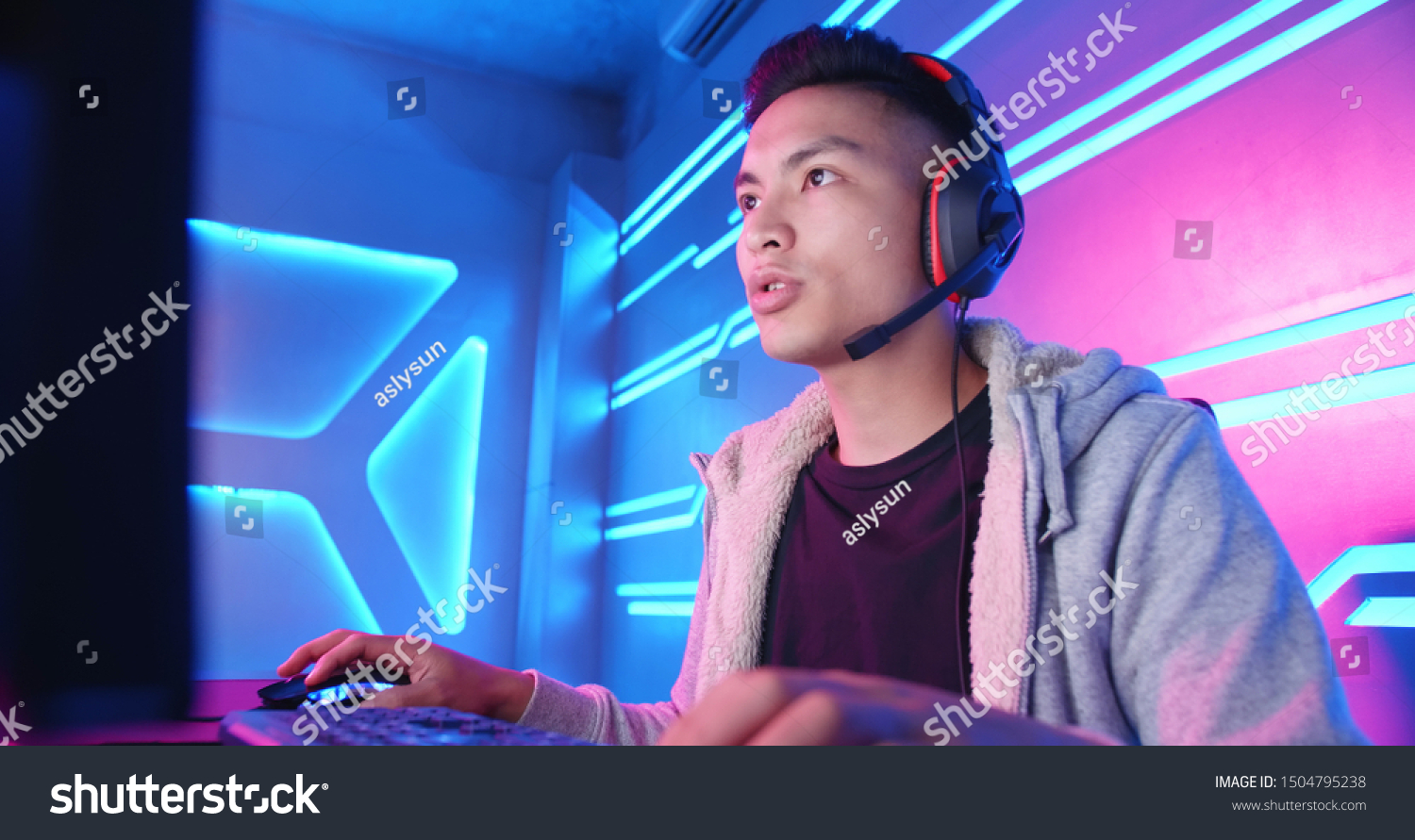 Young Asian Handsome Pro Gamer having live stream and playing in Online Video Game