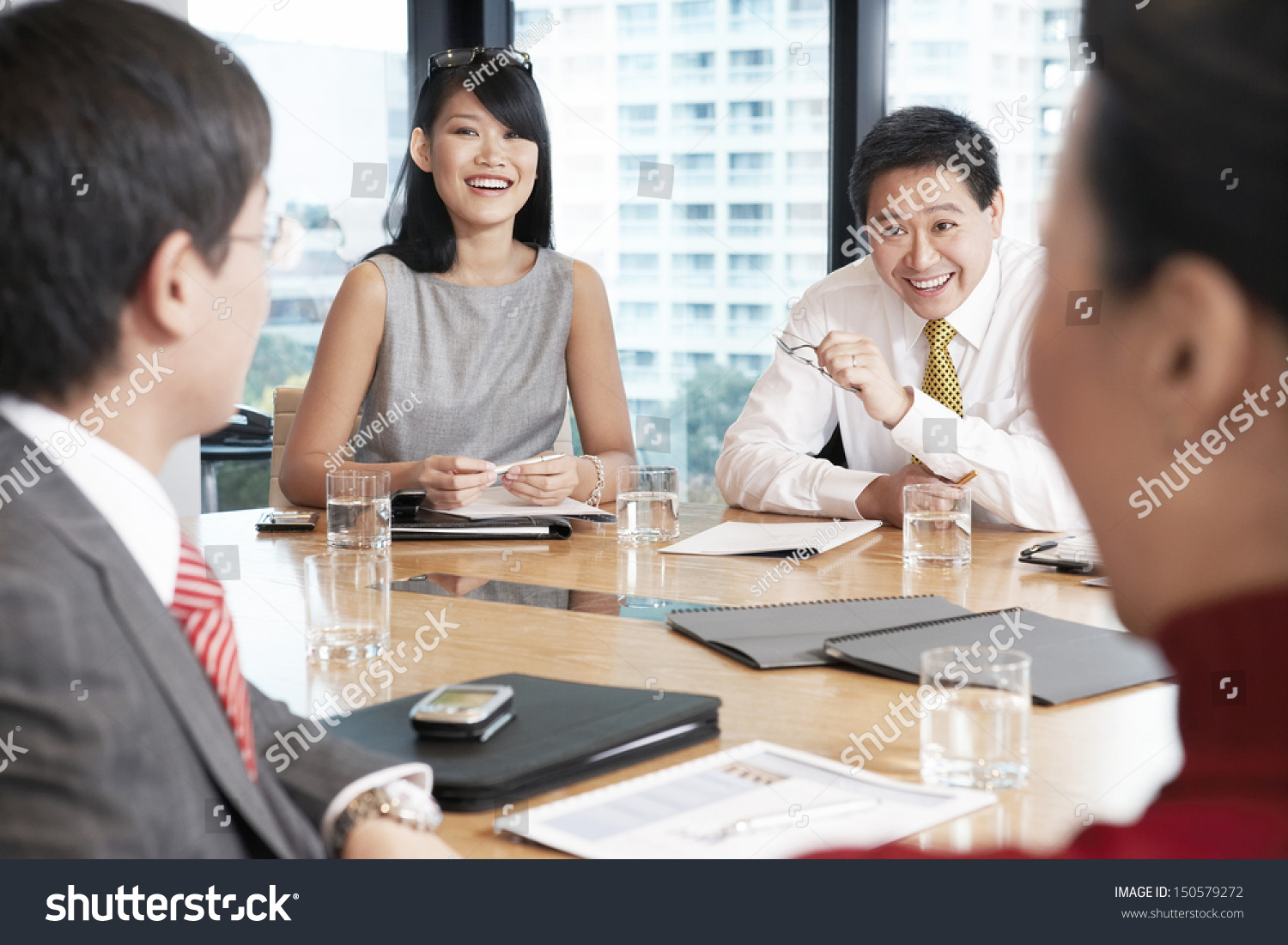 Young Asian business people having discussion in boardroom