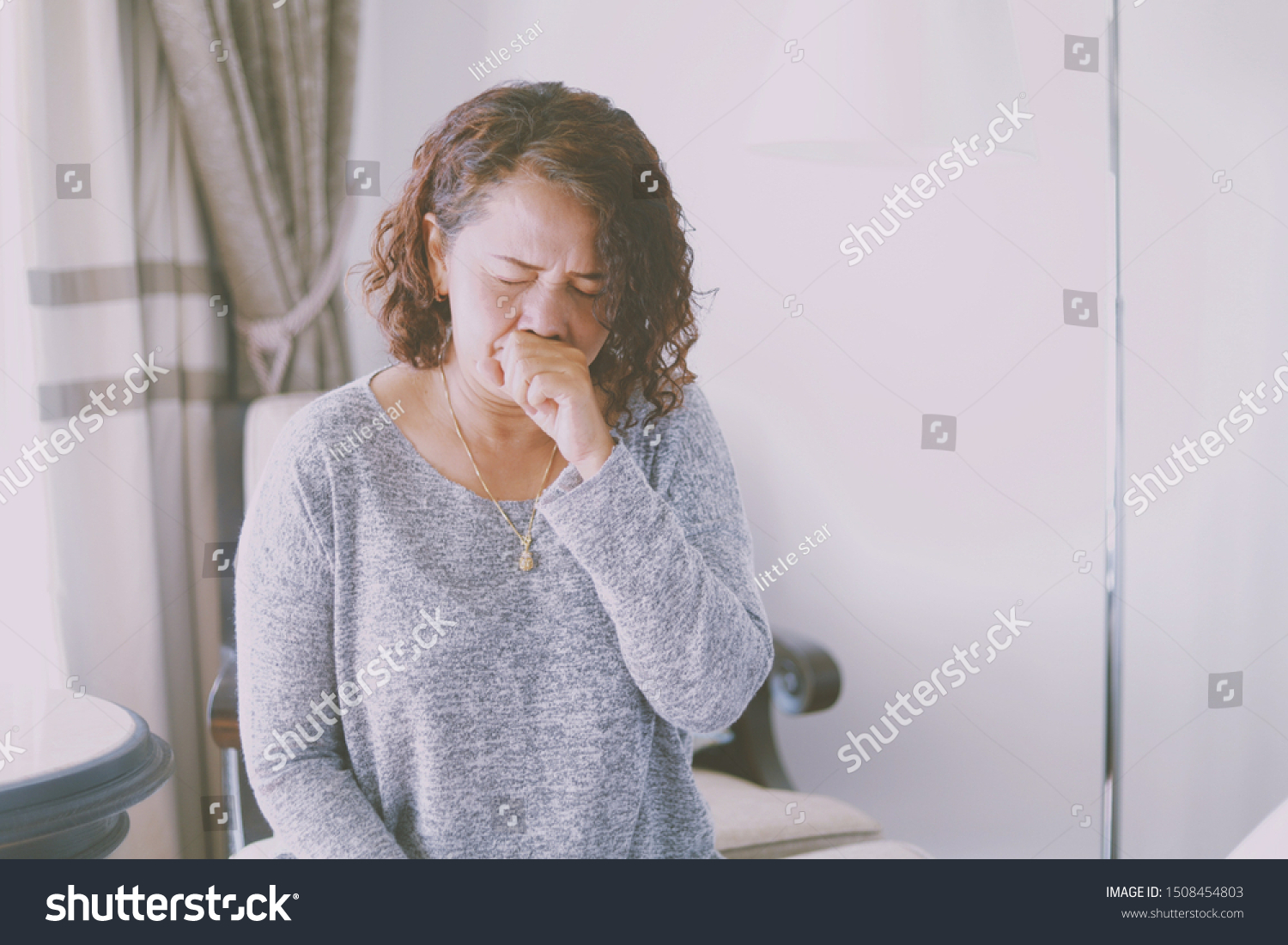 Elderly Asian woman feeling unwell She’s cough and headache in her bedroom.