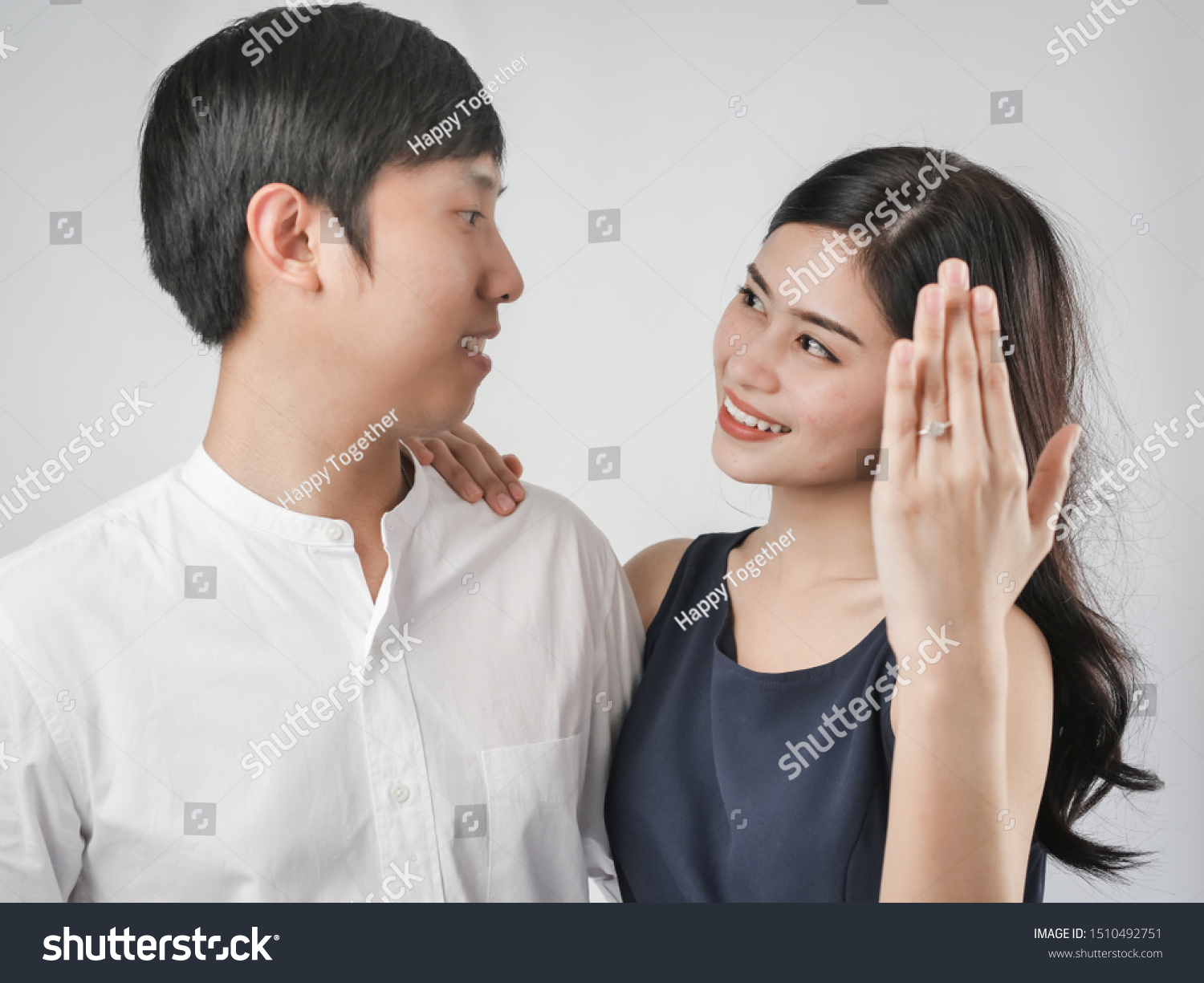 Happy woman showing engagement ring after proposal while is cuddling her boyfriend.