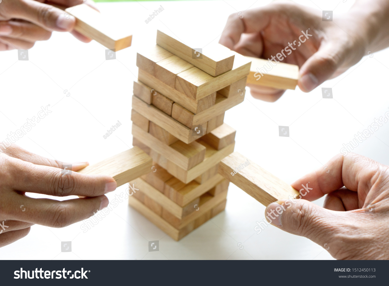 group of  Young businessman try to build wall and tower from wooden brick block go to top of a tower
