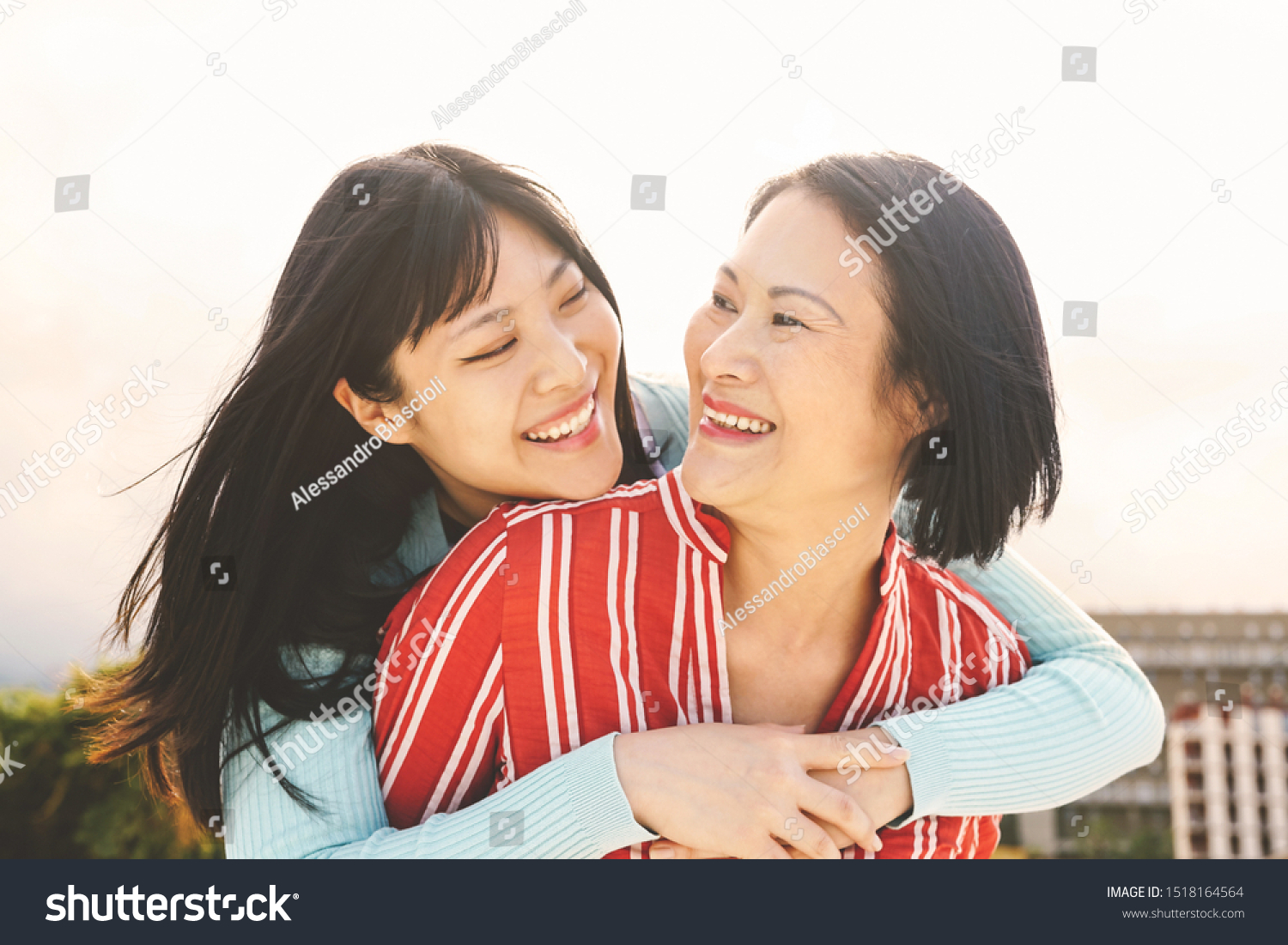Happy Asian mother and daughter having fun outdoor - Chinese family people spending time together outside - Love relationship and parenthood lifestyle concept