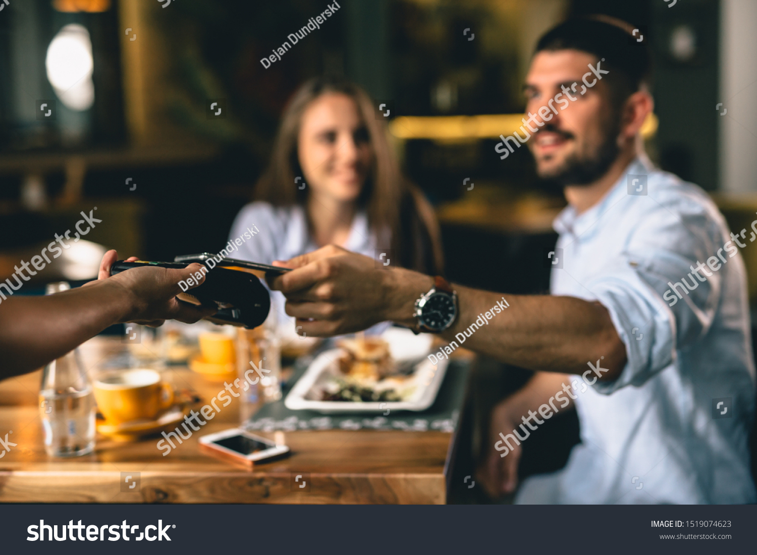 man paying for lunch in restaurant with mobile phone