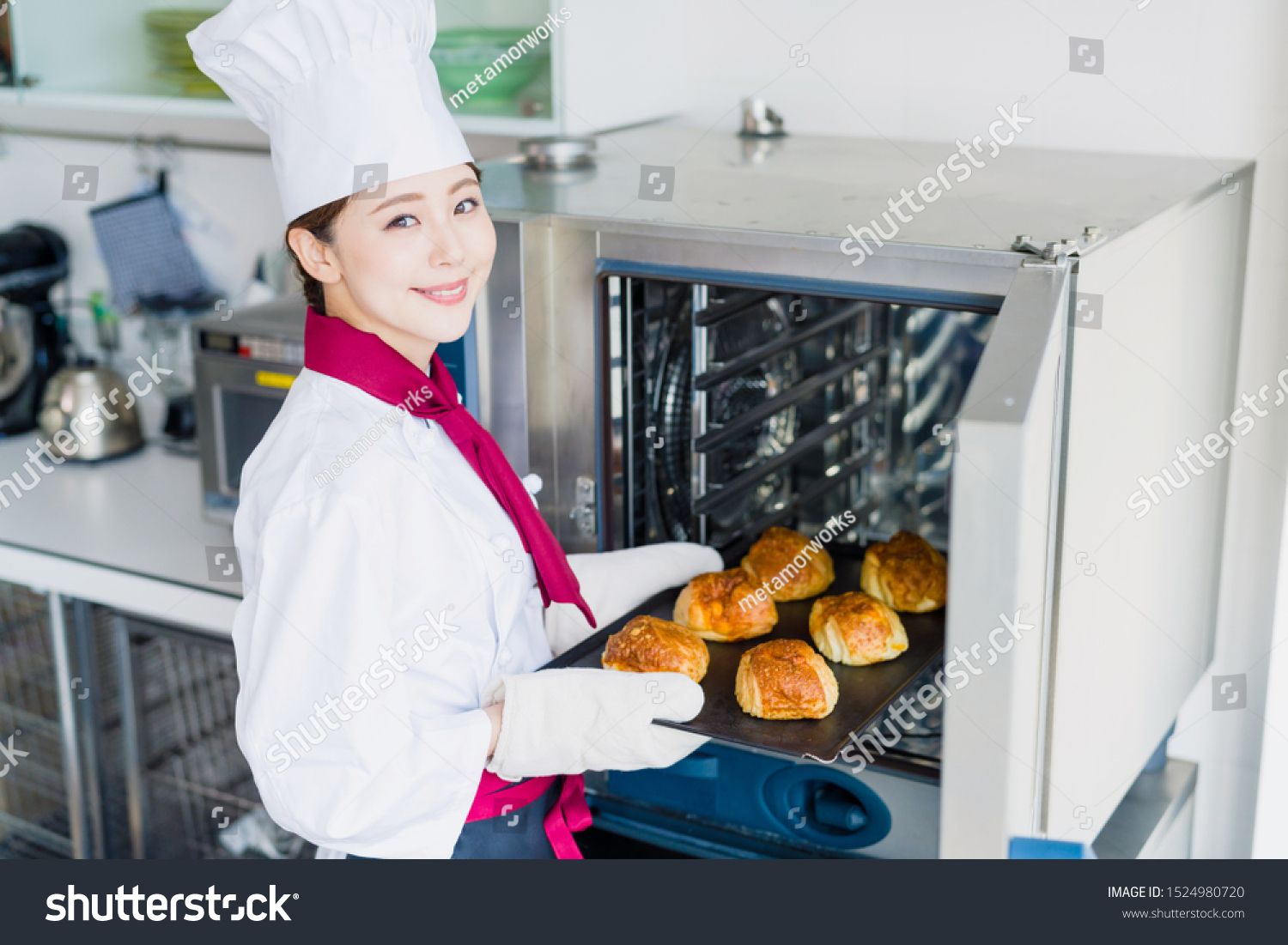 Young female baker baking breads.