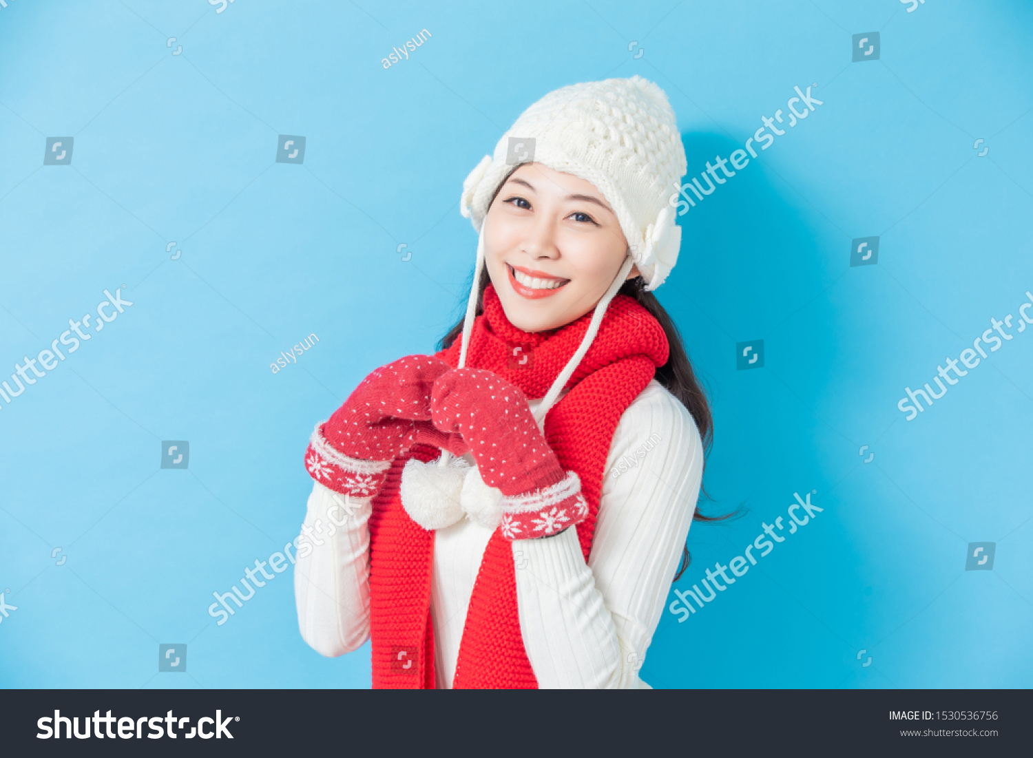 asian woman wear winter clothes and smile isolated on blue background