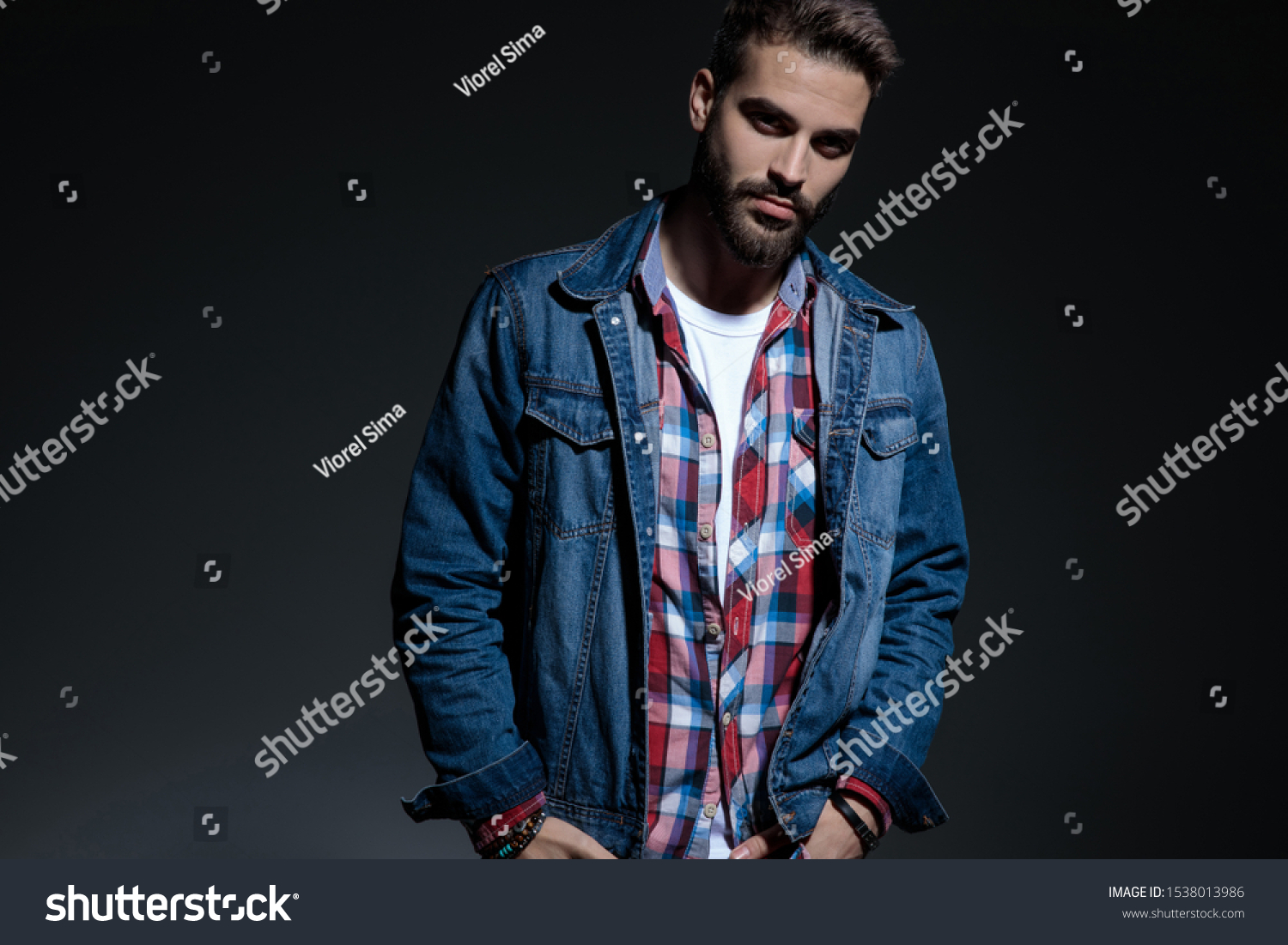 charming looking young man holding both hands in his pockets