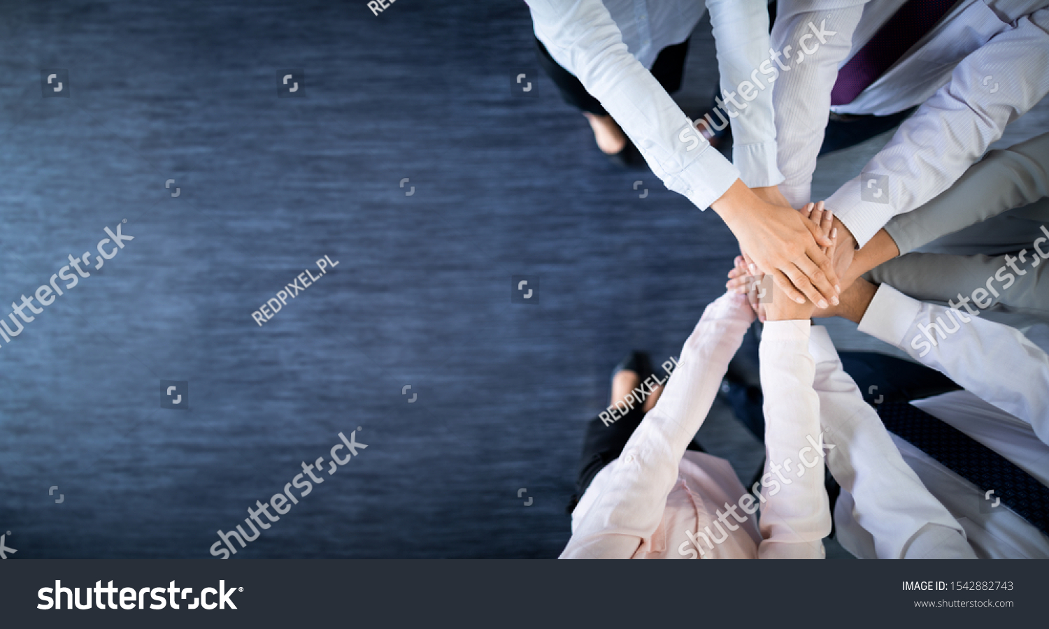 Close up top view of young business people putting their hands together. Stack of hands. Unity and teamwork concept.